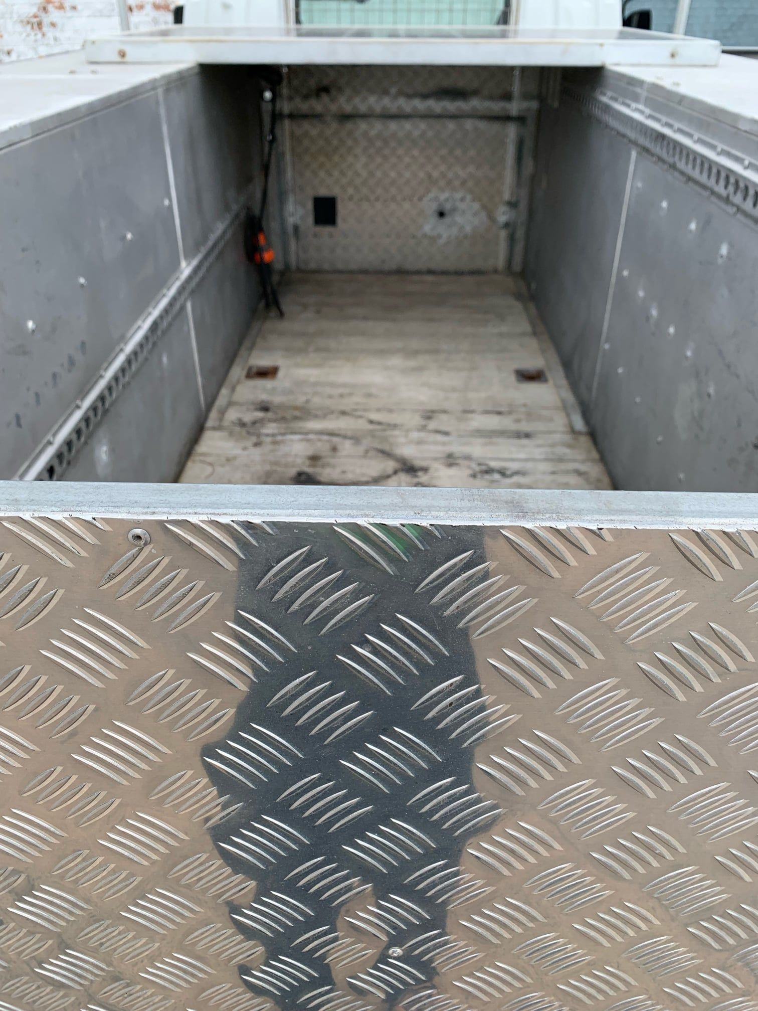 Inside of a Truck Bed With a Diamond Plate Floor and Gray Walls — A.M.D. Automotive Services in Mackay, QLD