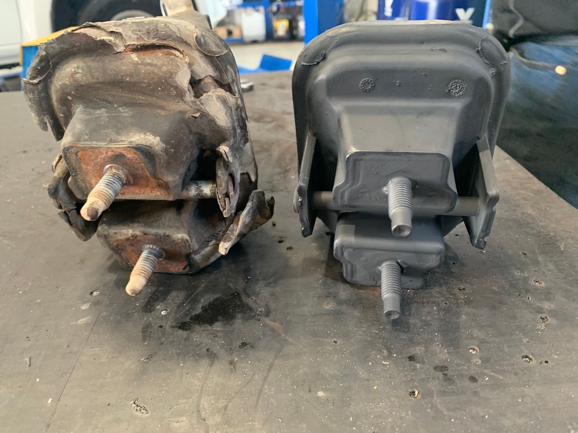 Comparison of a Worn and New Black Engine Mount on a Workbench — A.M.D. Automotive Services in Bowen, QLD