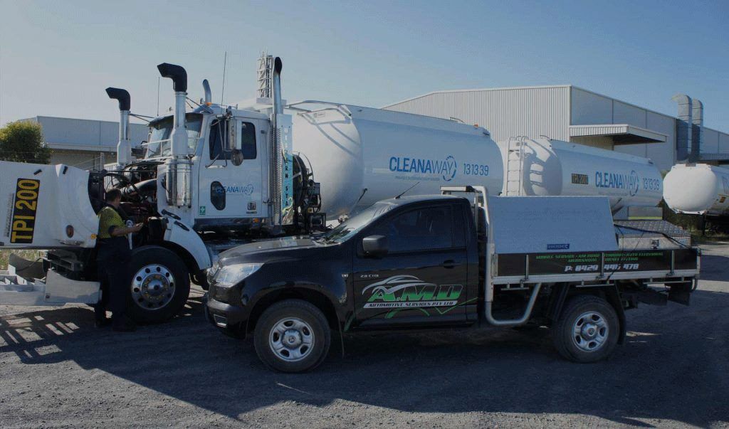 Black Truck and Large White Tanker Truck Parked Outside — A.M.D. Automotive Services in Mackay, QLD