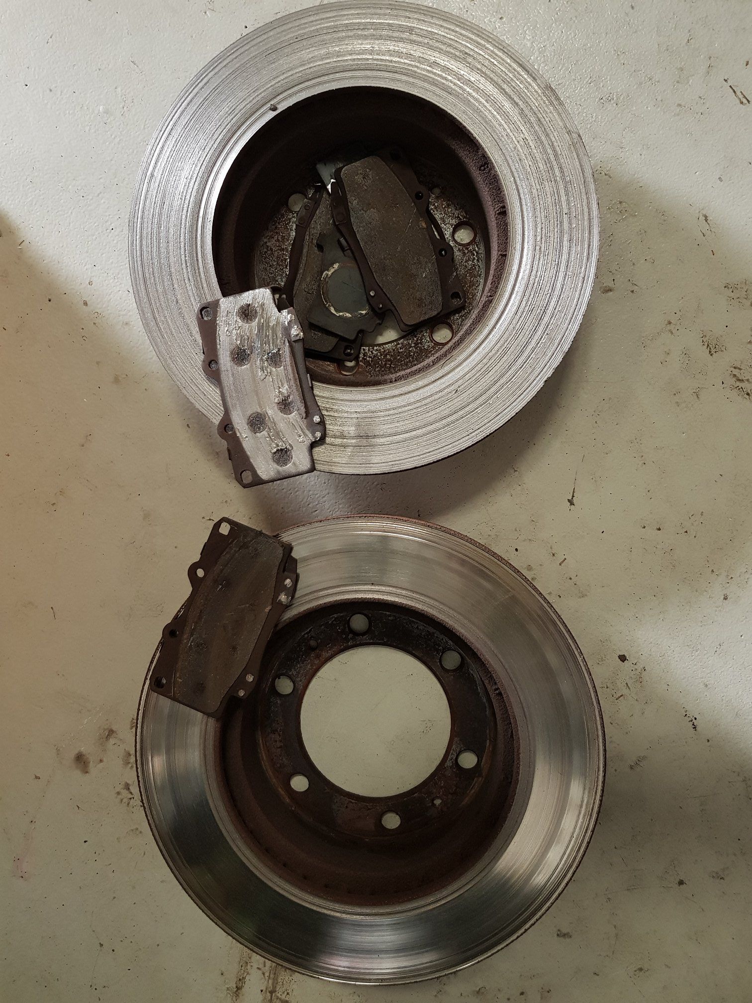 Two Car Brake Rotors With Brake Pads, One Rotor Older and Worn — A.M.D. Automotive Services in Mackay, QLD
