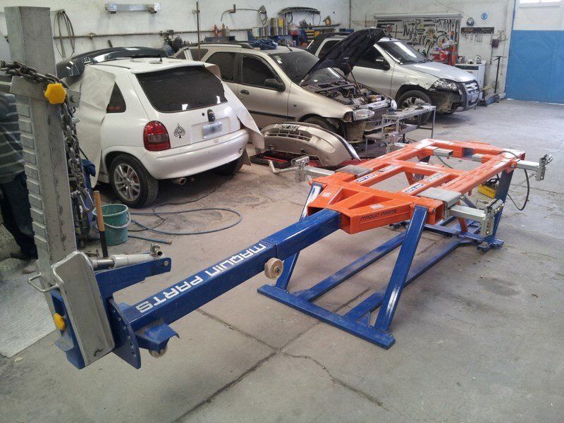 En un garaje se está trabajando en una fila de coches.