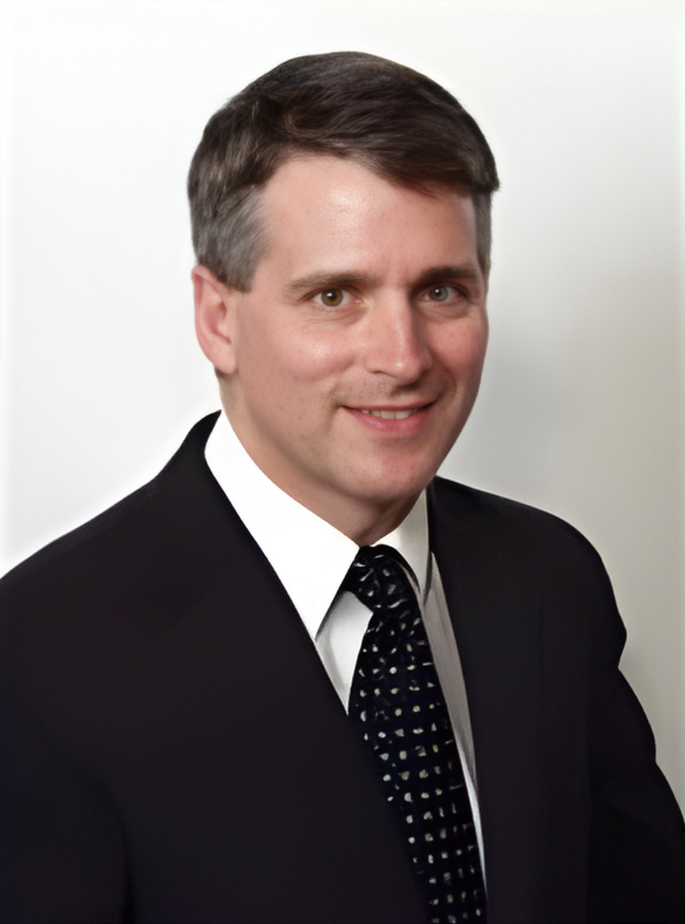 A smiling doctor in a lab coat with a stethoscope around his neck.