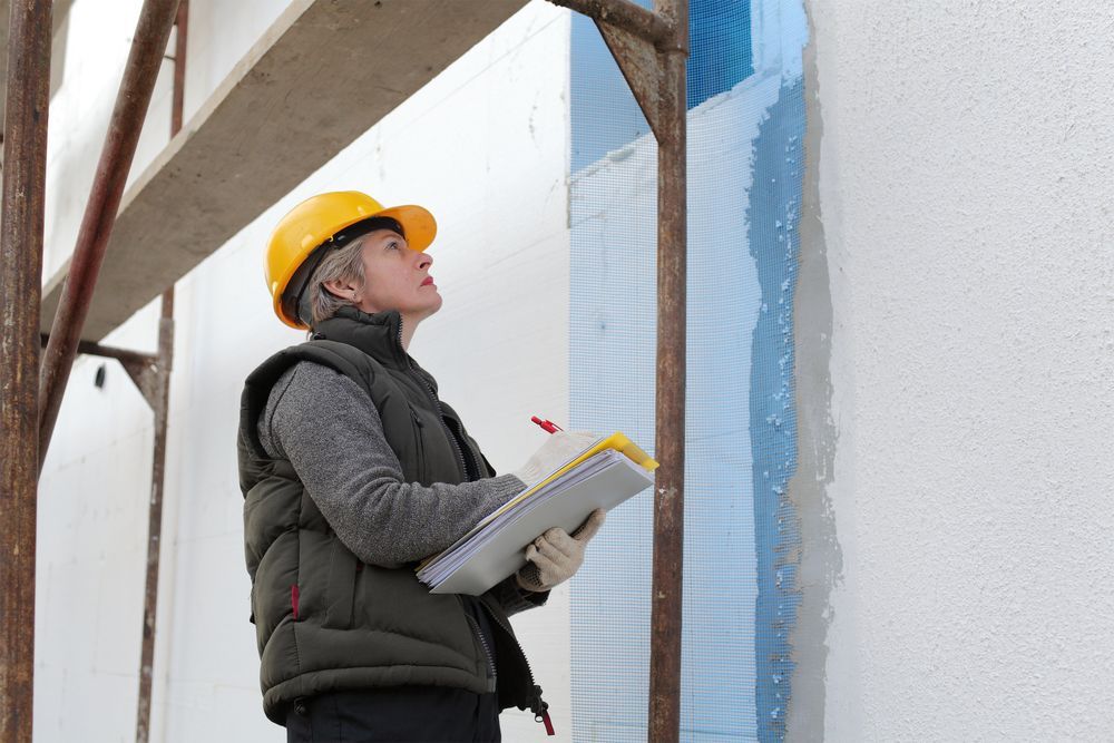 inspector examine styrofoam insulation of house facade