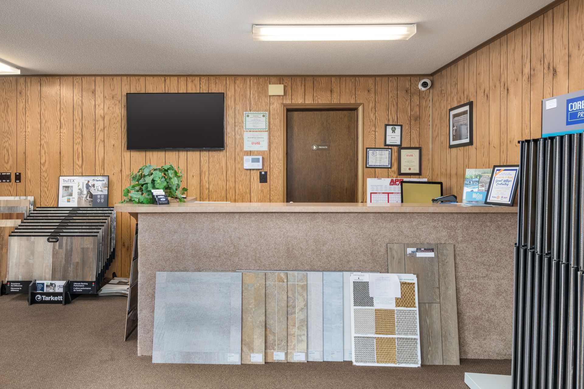 A counter in a room with wood paneling and a flat screen tv