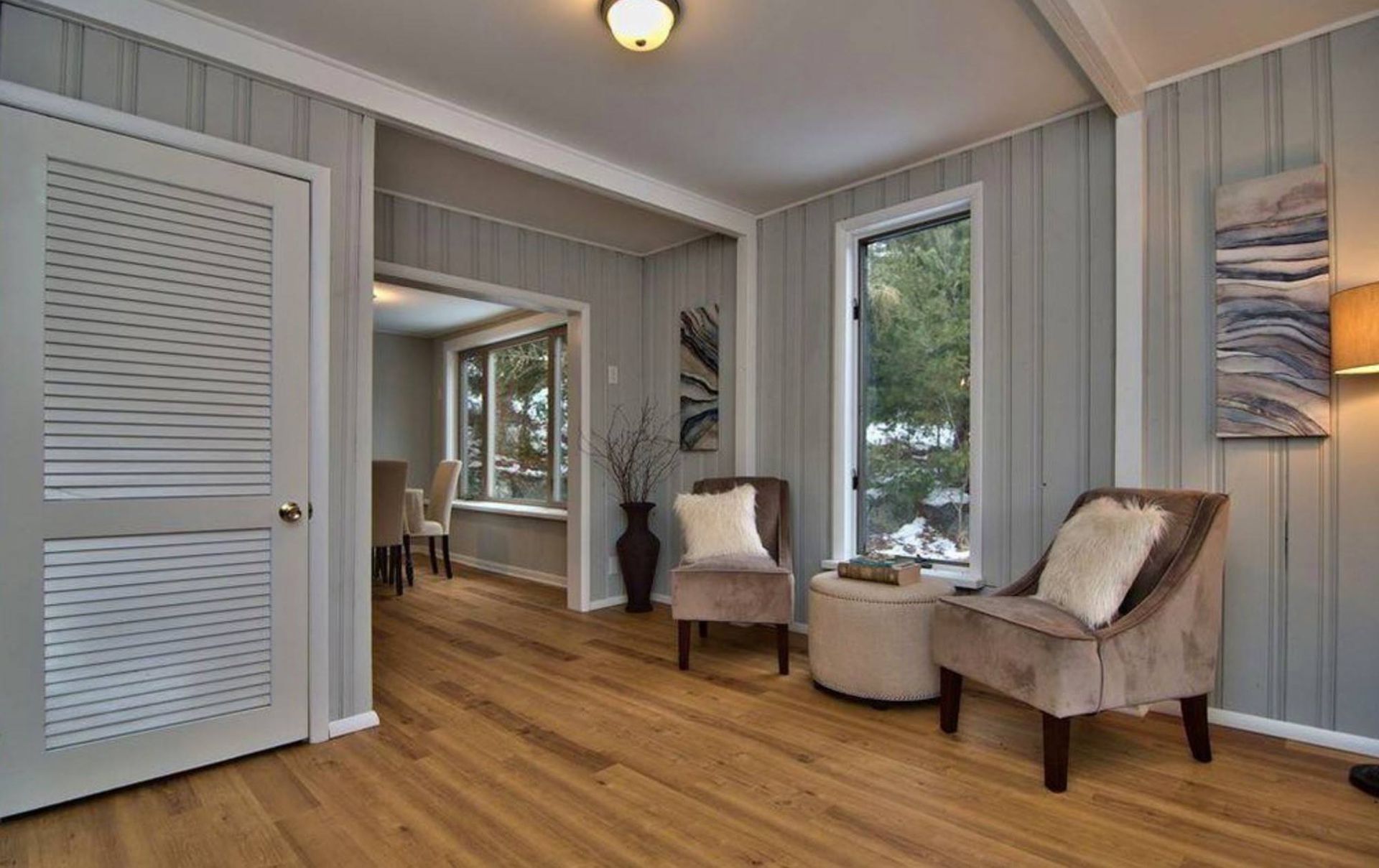 There are two chairs and a table in the living room.