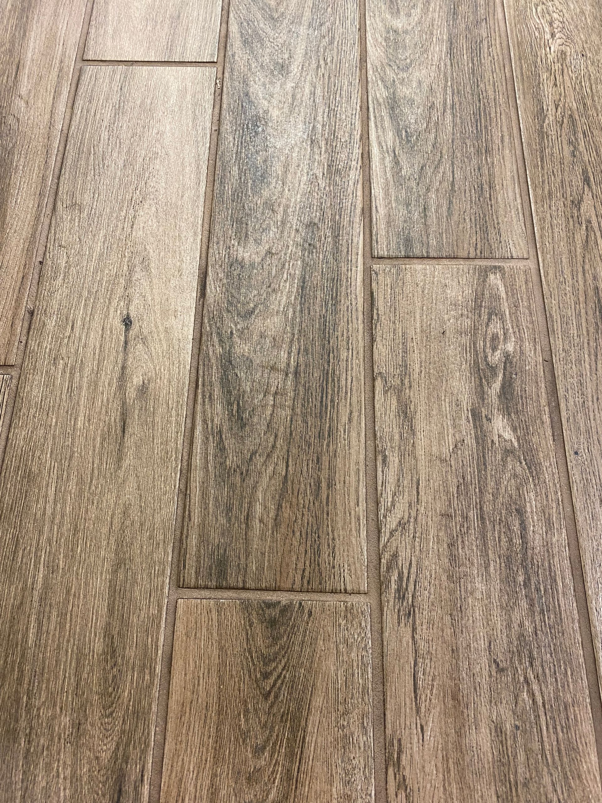 A close up of a tile floor that looks like wood.