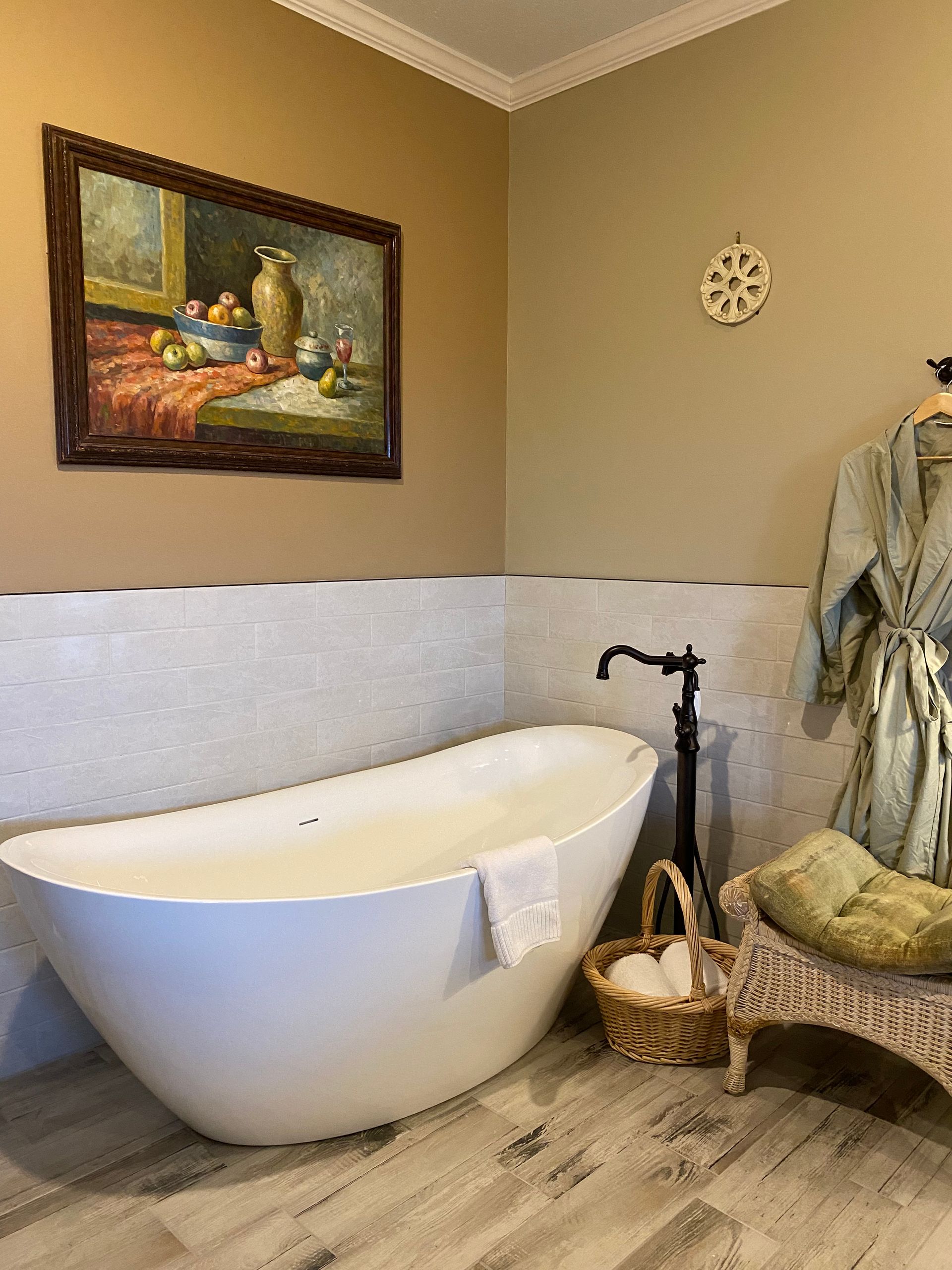 A bathroom with a bathtub and a painting on the wall.