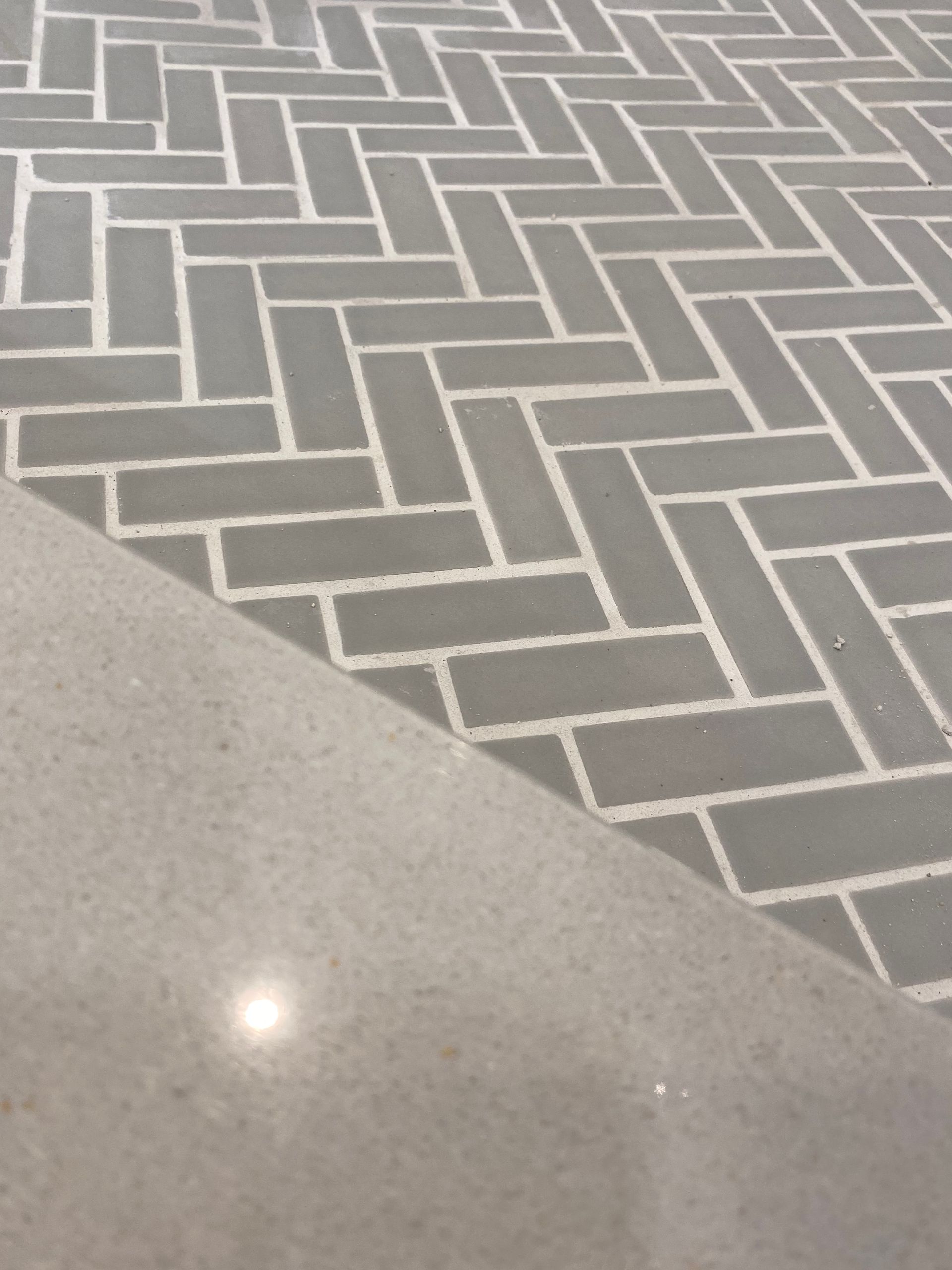 A close up of a herringbone tile floor