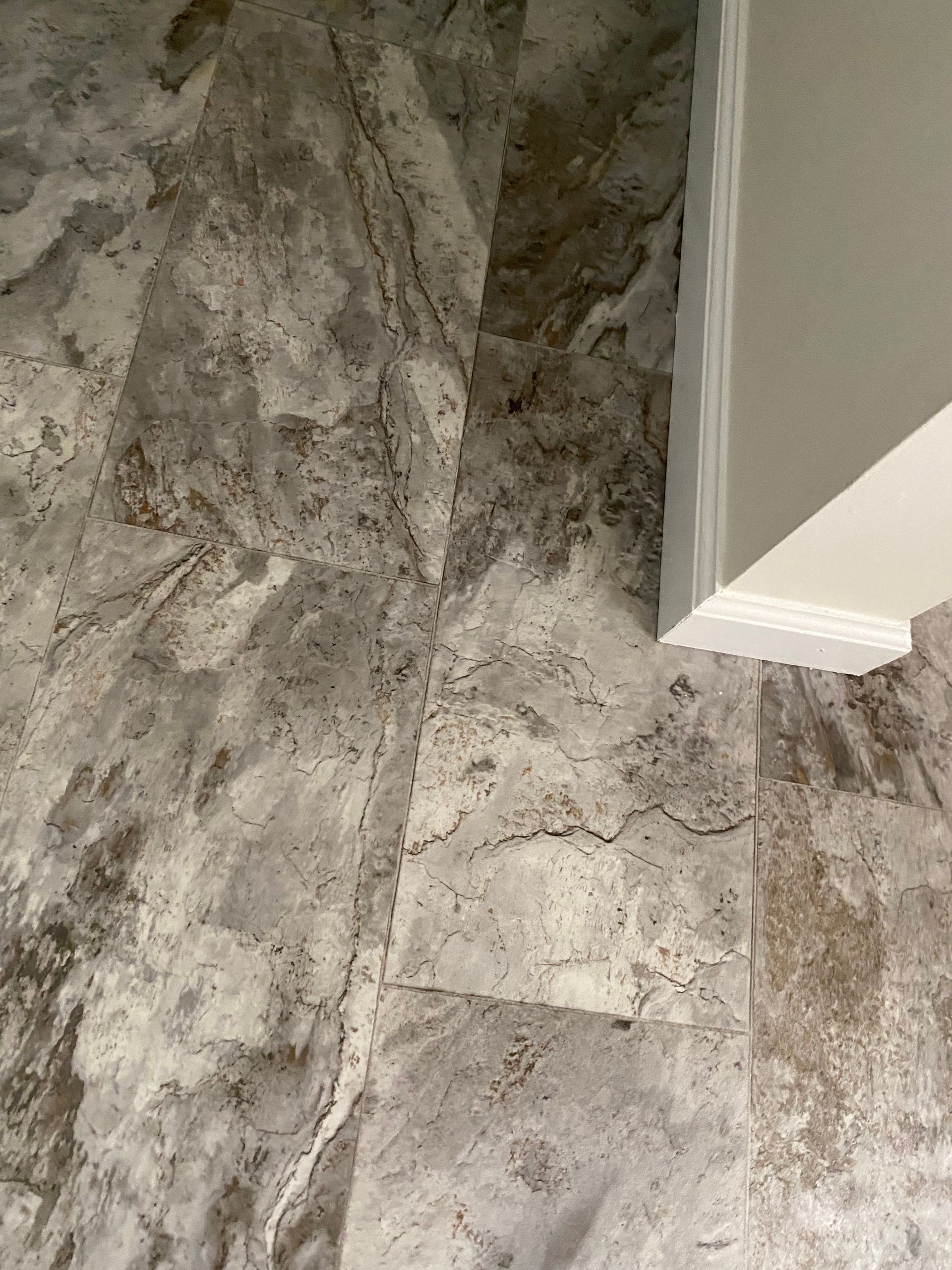 A close up of a tile floor next to a staircase.