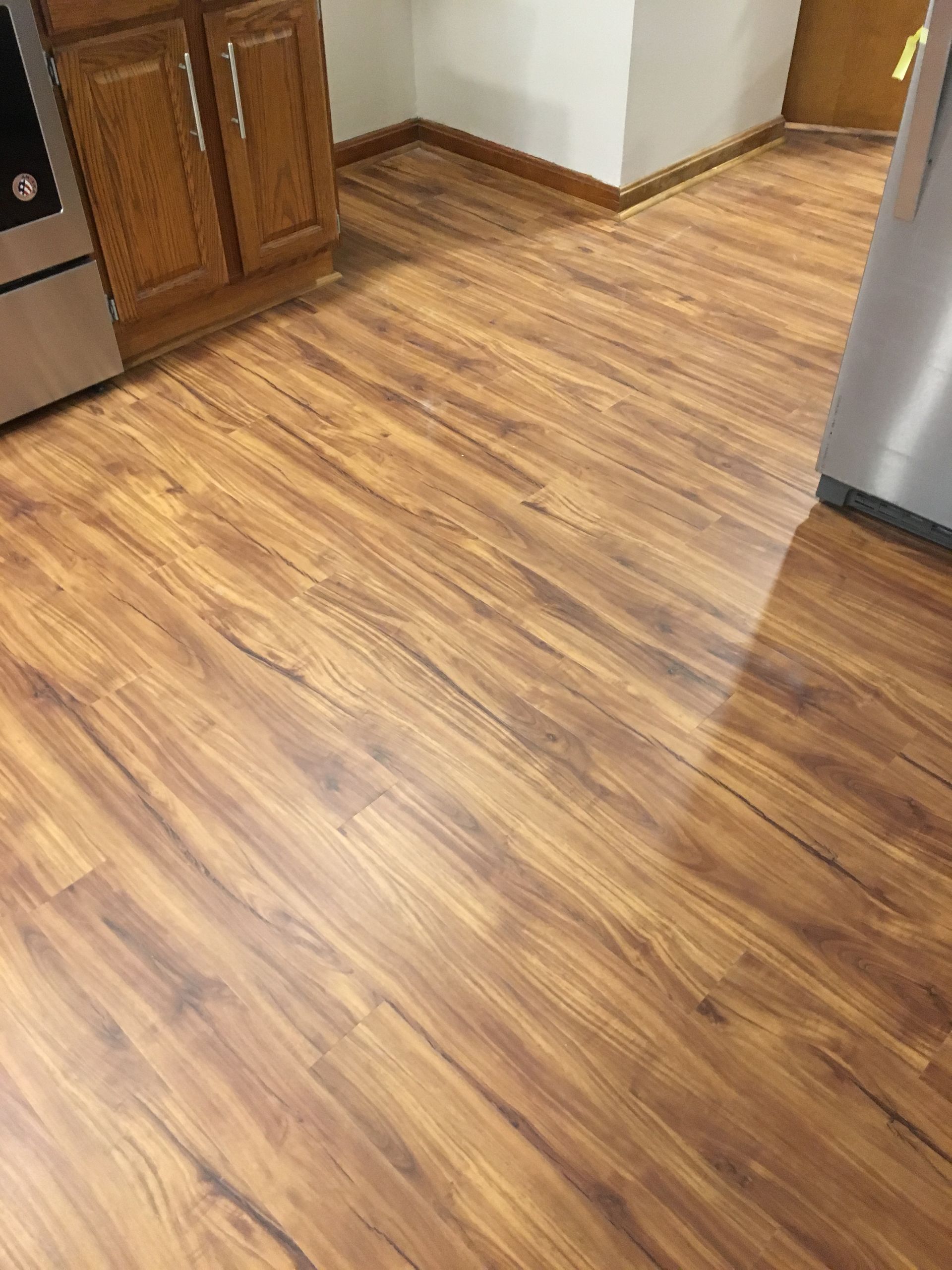 A kitchen with a wooden floor and stainless steel appliances.
