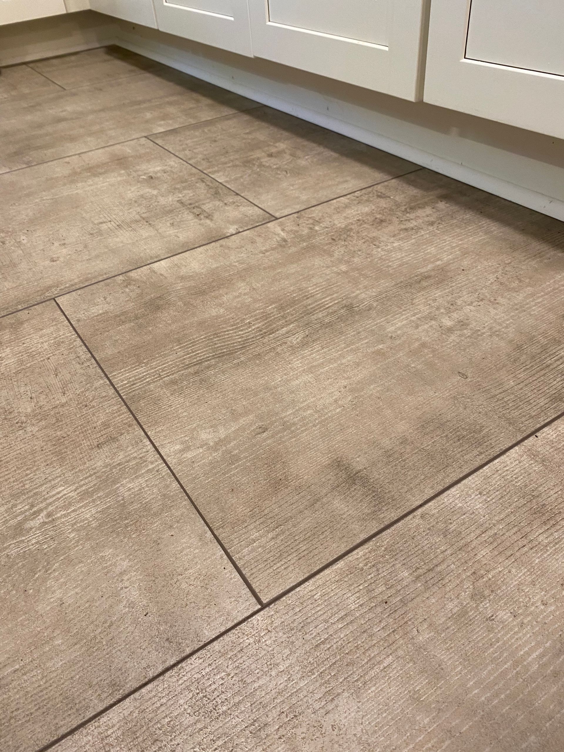 A close up of a tiled floor in a kitchen.