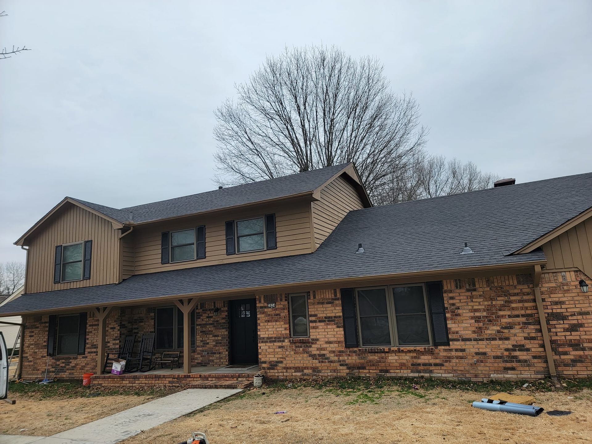 A large brick house with a metal roof and wooden siding.
