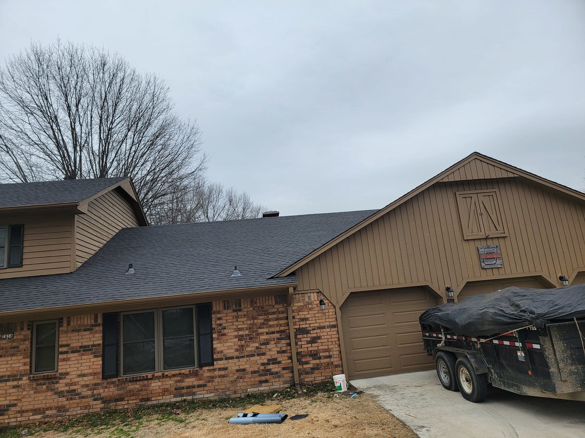 A truck is parked in front of a brick house.