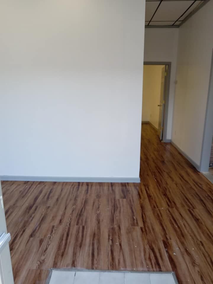 An empty room with a wooden floor and white walls.