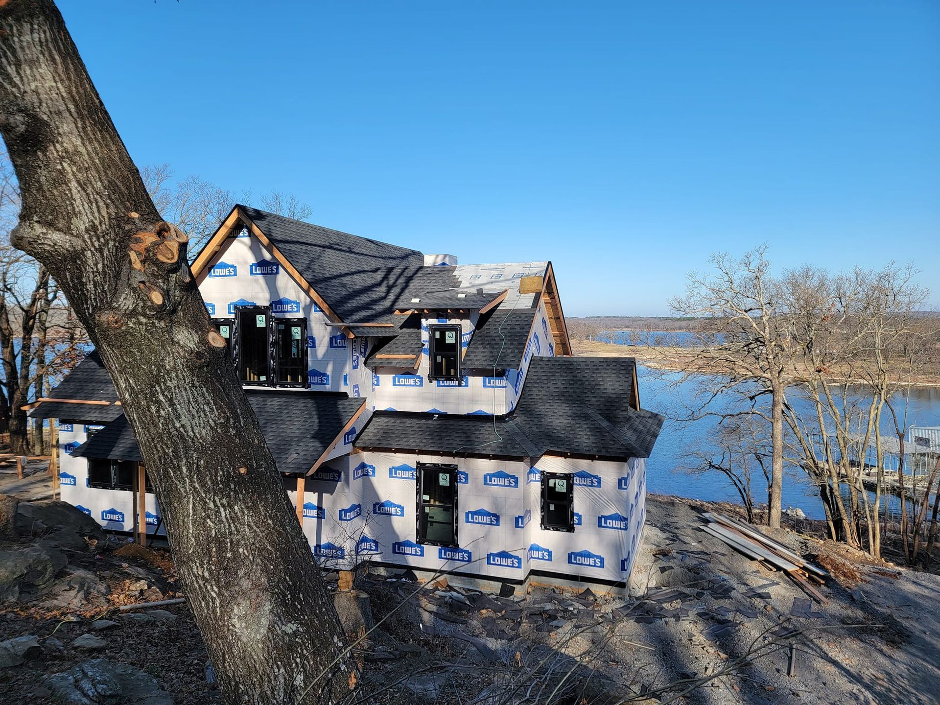 A house is being built next to a body of water.