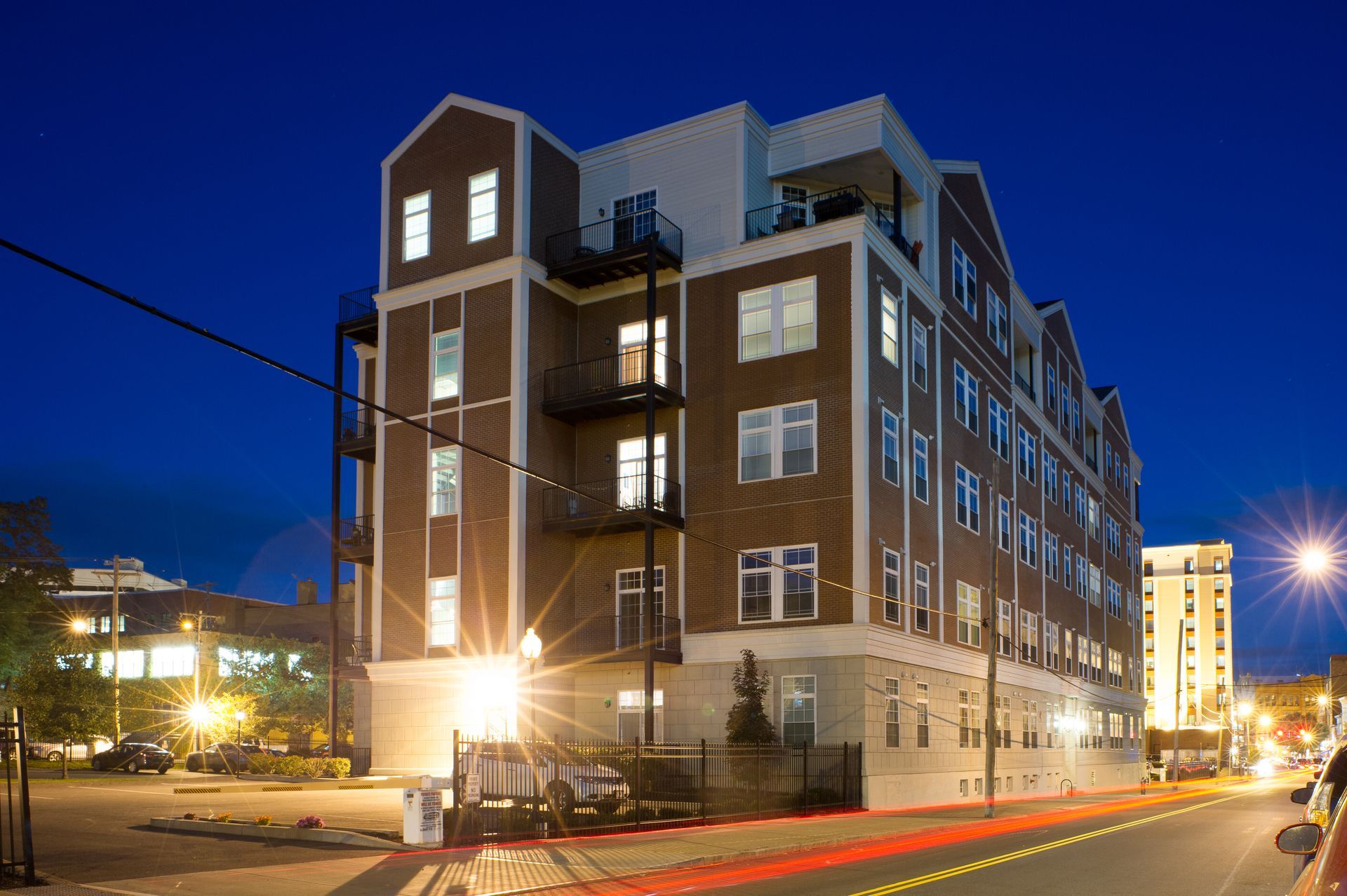 A large brick building with a lot of windows is lit up at night
