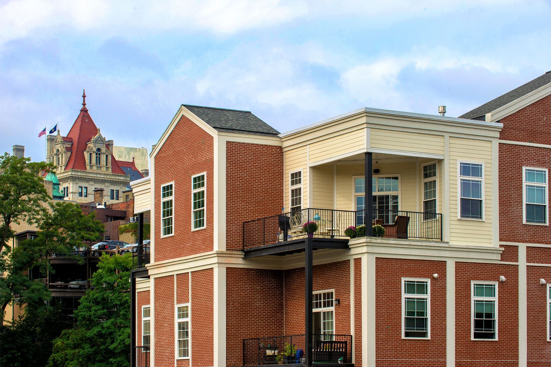 A large brick building with a balcony and a castle in the background