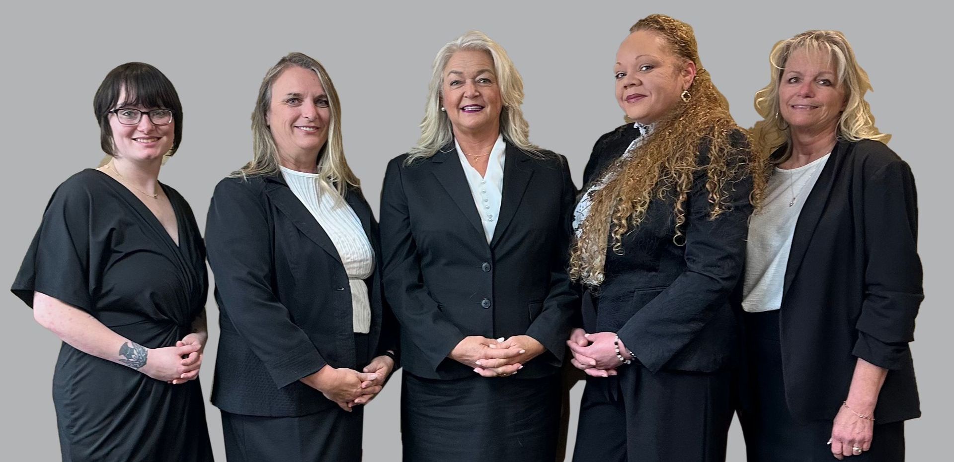 A group of women in suits are posing for a picture.