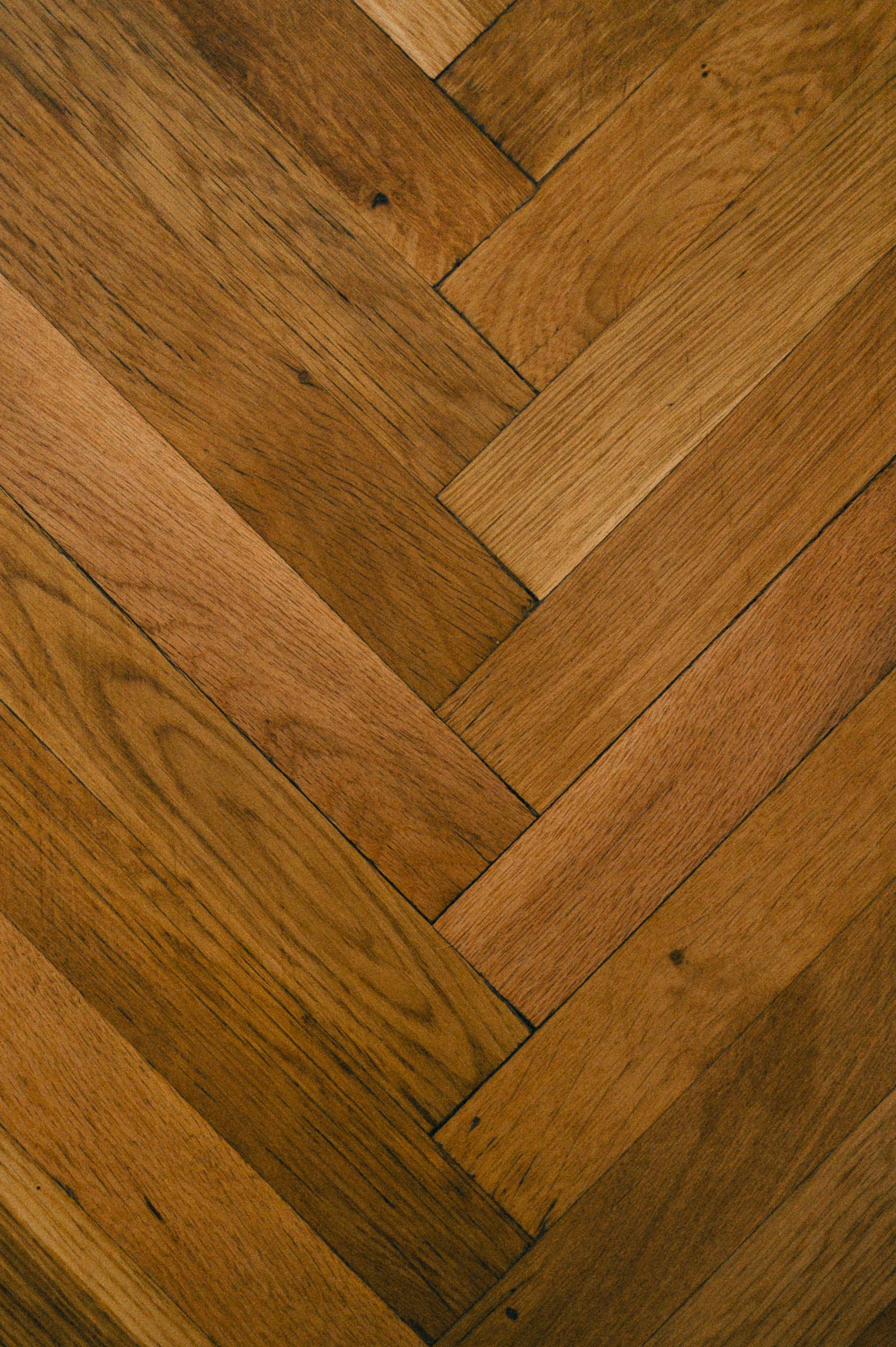 Suelo de madera con diseño de espiga en tonos marrones cálidos.