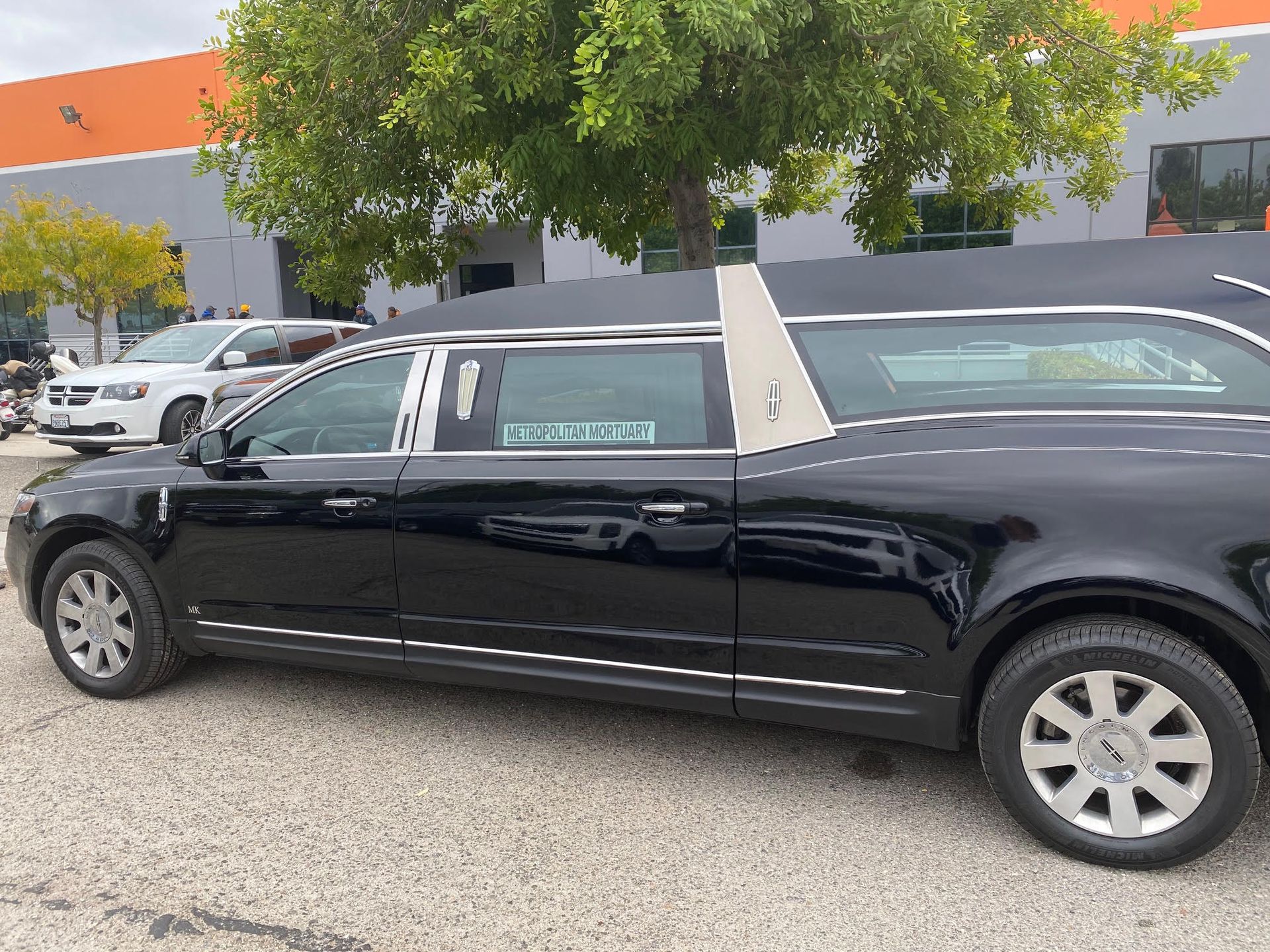 A photo of a black hearse with the name of the funeral home in the window.