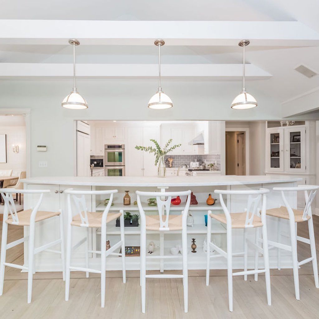 A kitchen with a table and stools in front of it