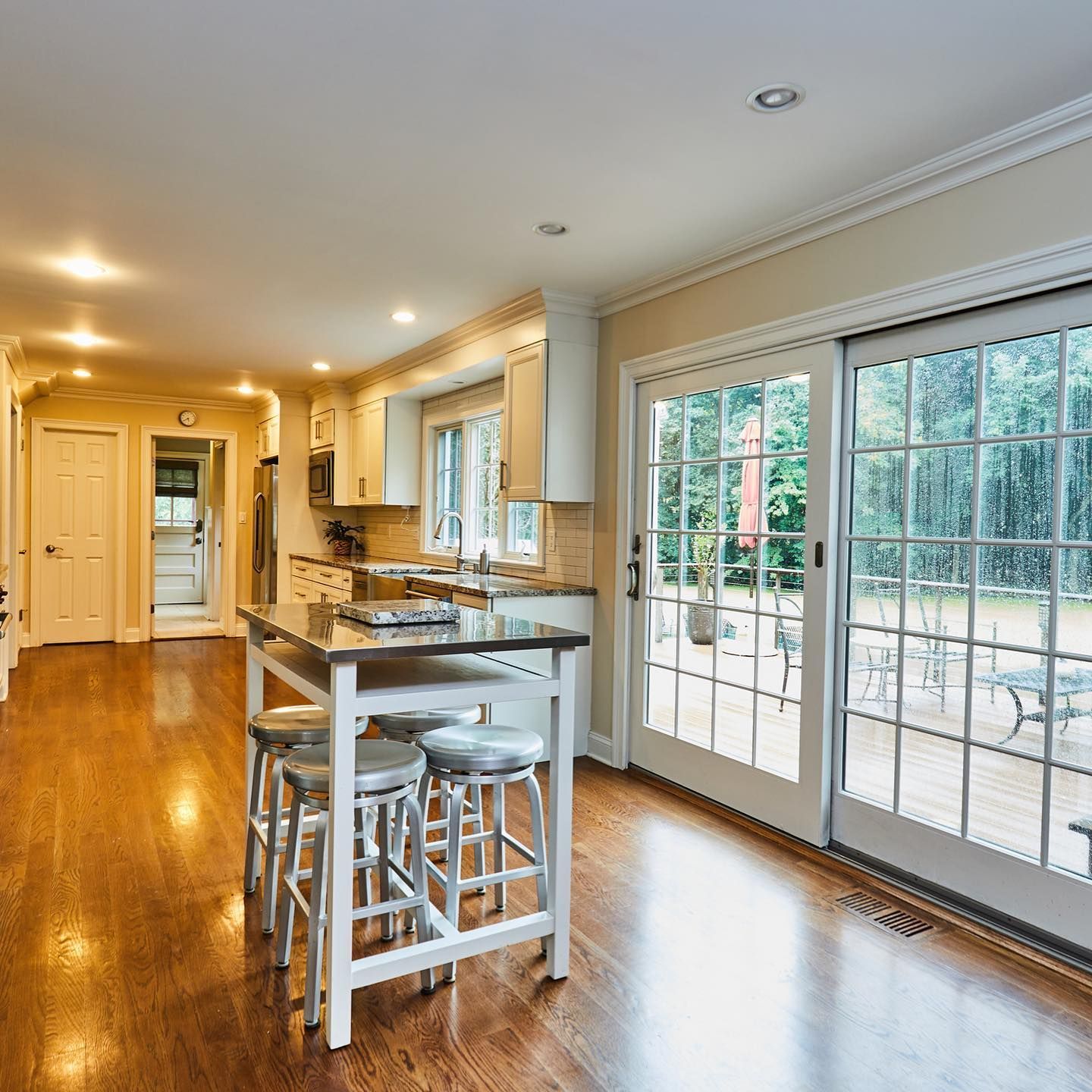 A kitchen with a table and stools and sliding glass doors