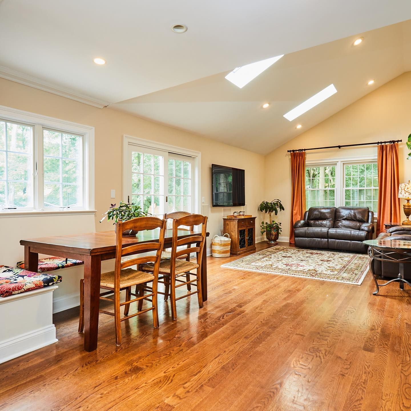 A living room with hardwood floors and a table and chairs
