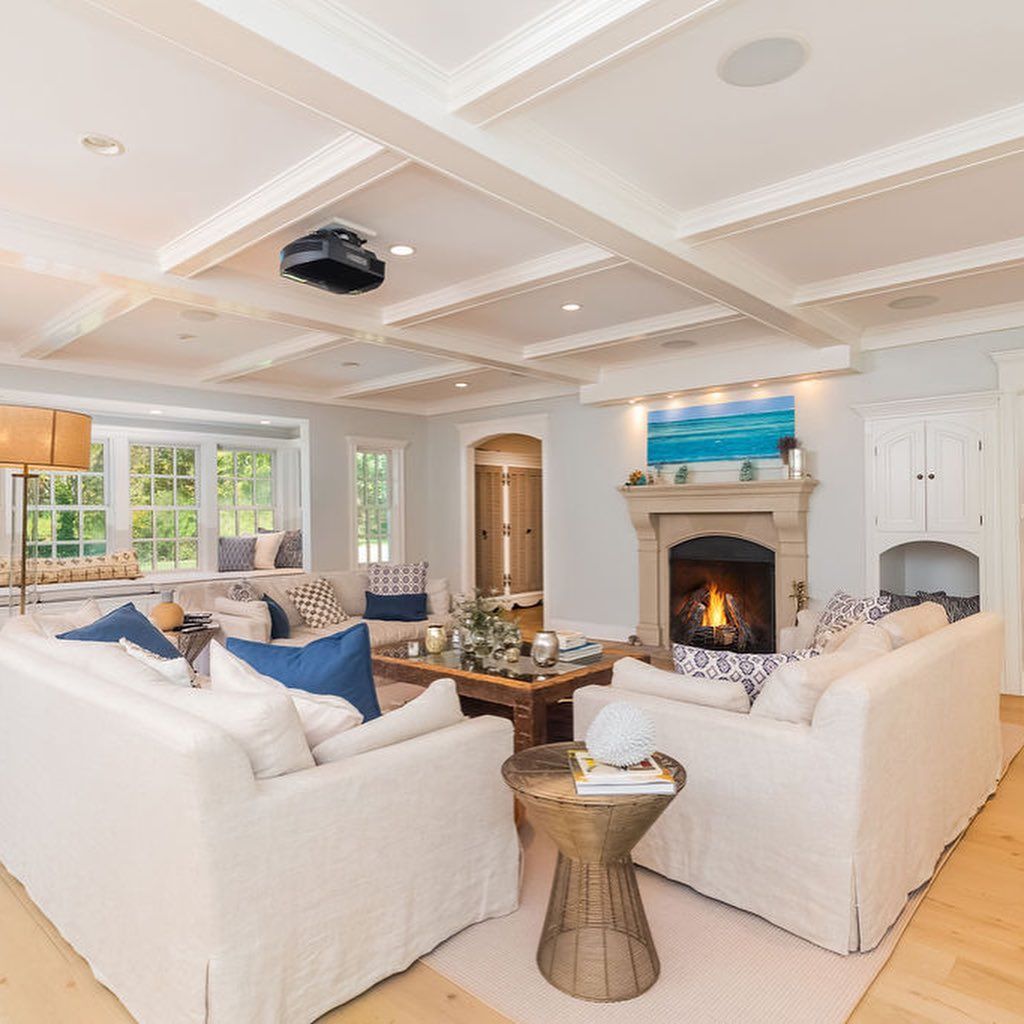 A living room with white furniture and a fireplace