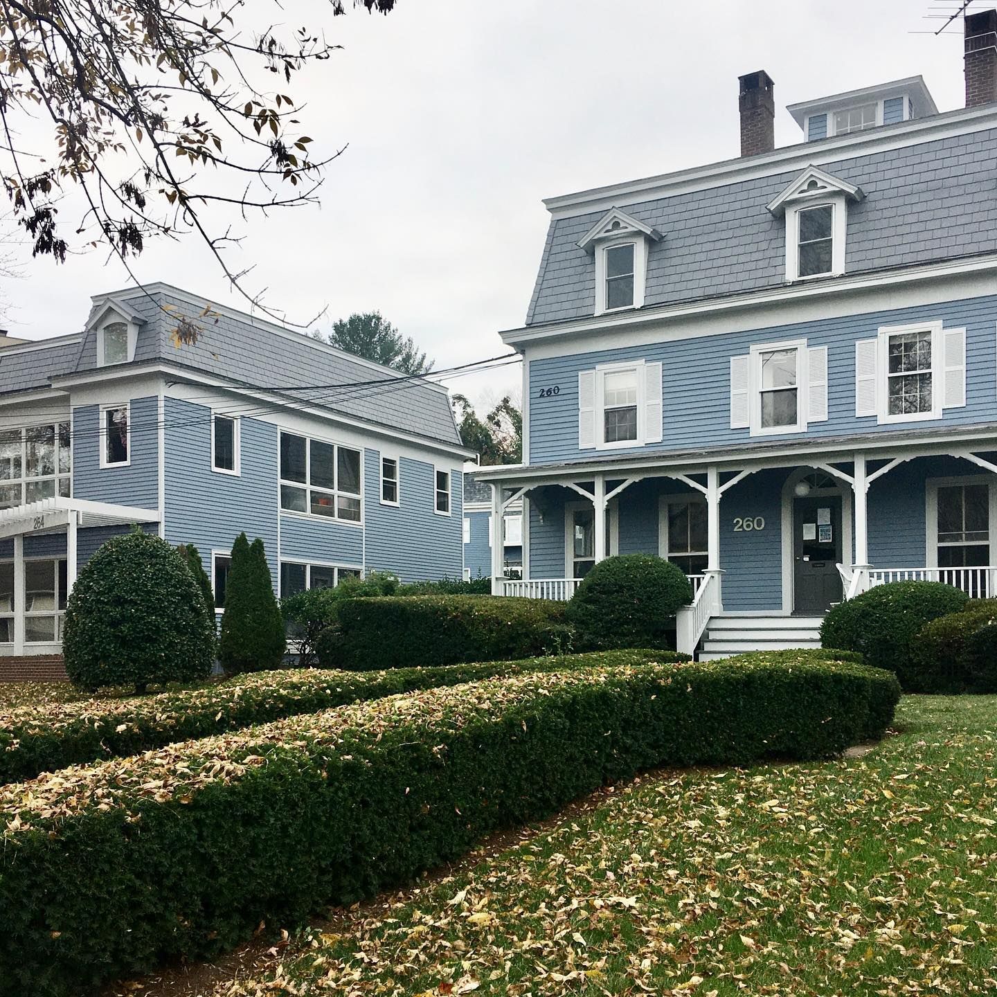 A blue house with a white porch and a gray roof