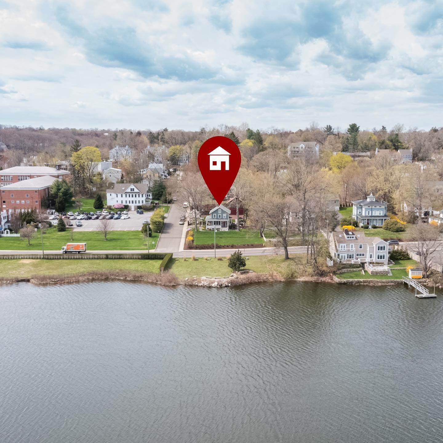 An aerial view of a house on the shore of a lake
