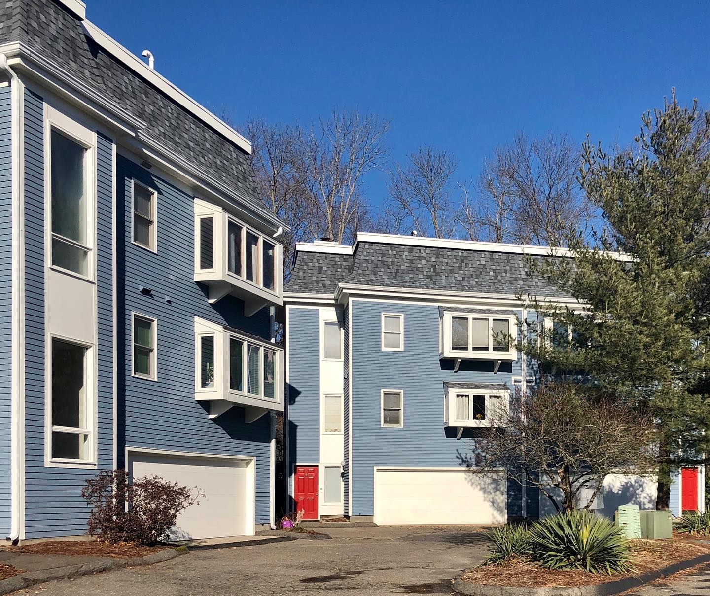 A blue building with white trim and a red door