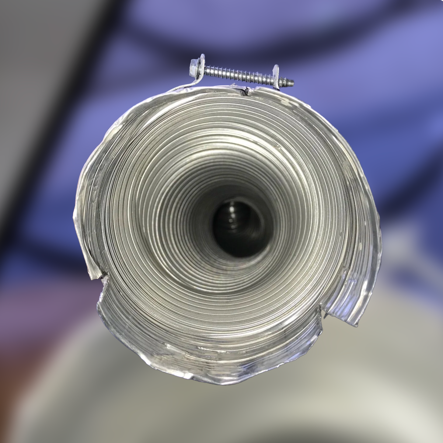 Inside view of a metallic, corrugated pipe with a clamp at the top. The inner part is dark.