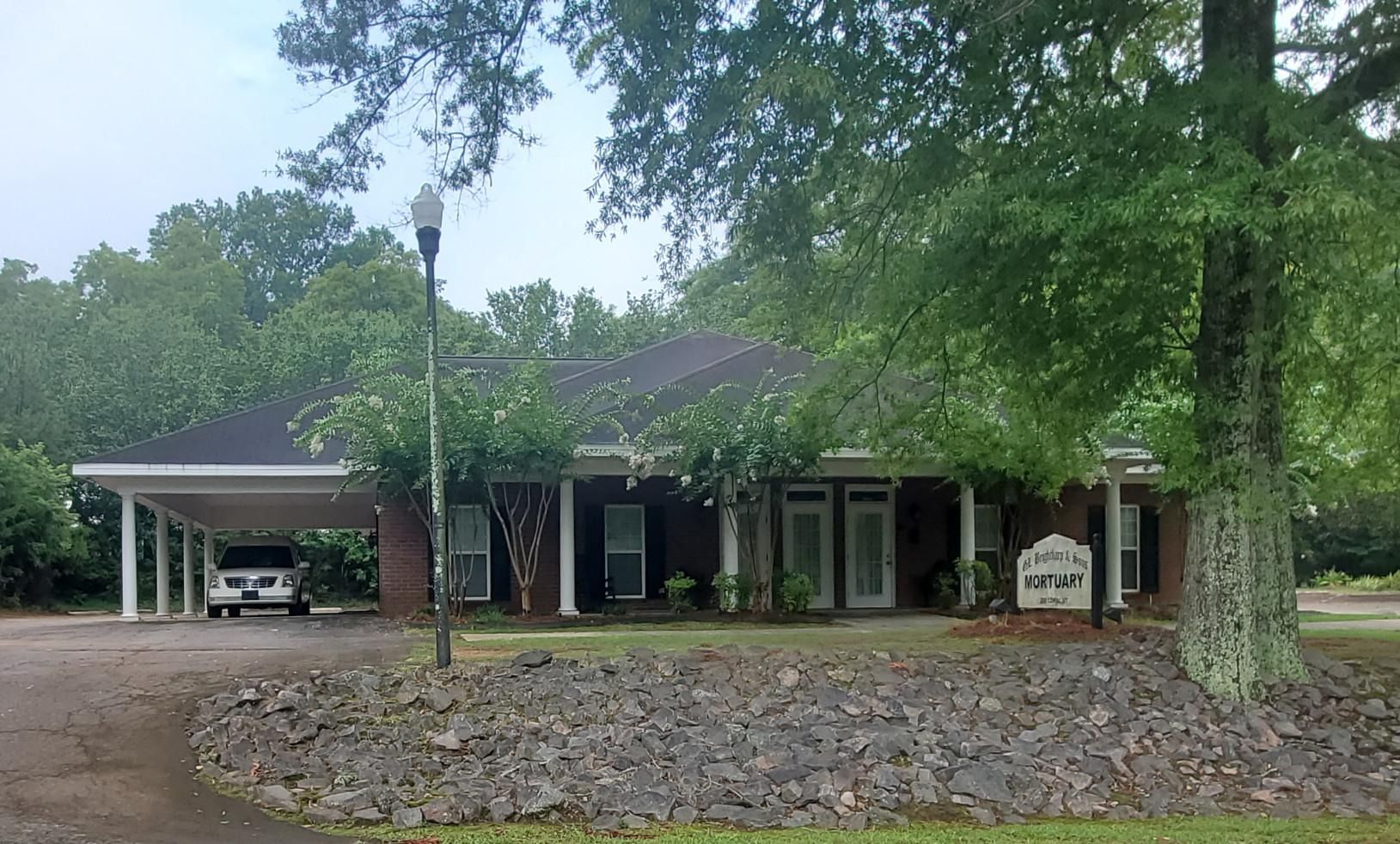 The inside of a church with rows of wooden benches and stained glass windows.