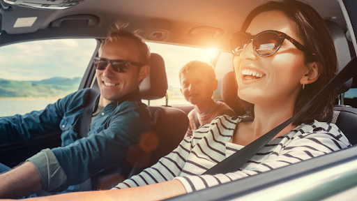 A happy family of three is enjoying a road trip together. 