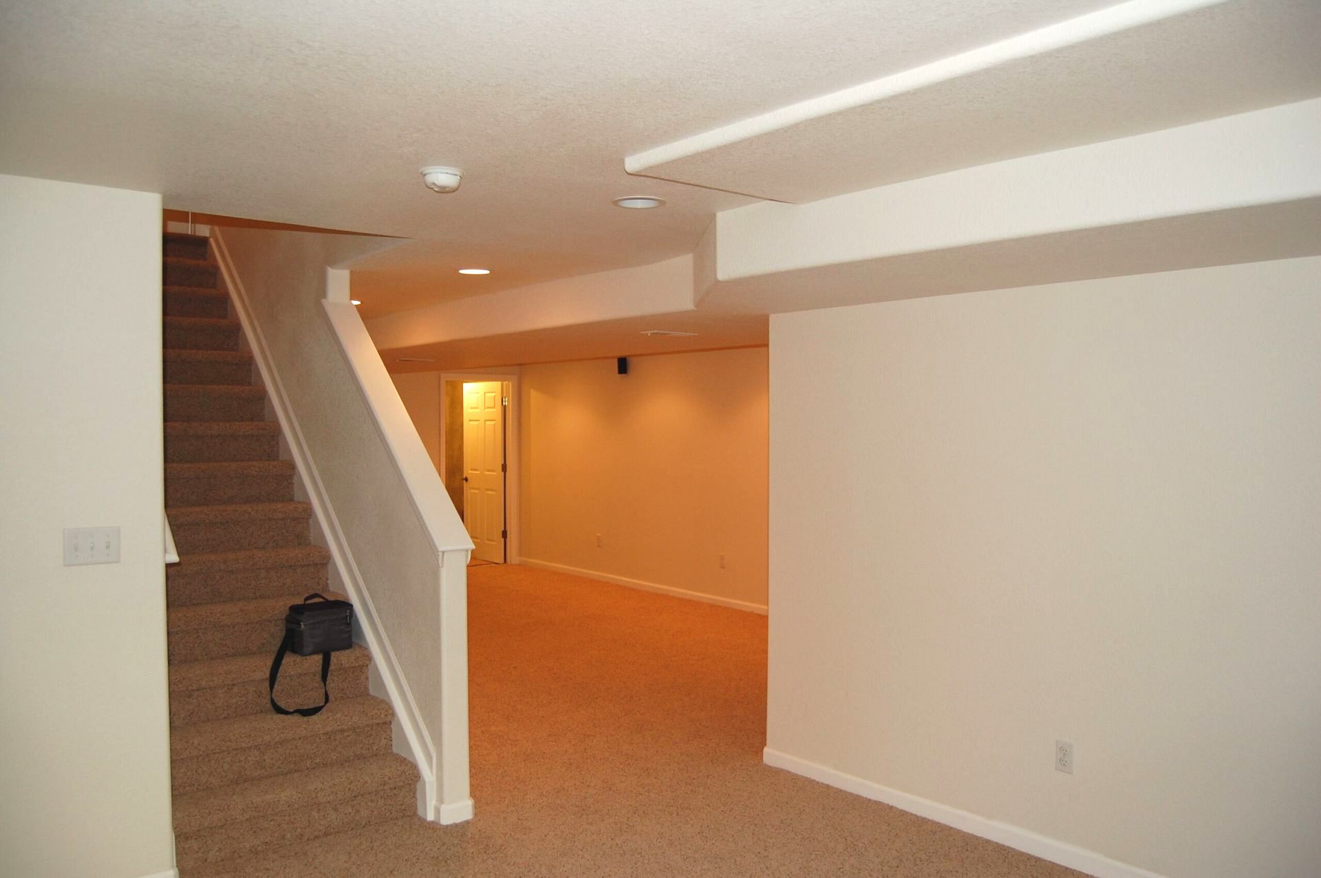 An empty basement with stairs leading up to the second floor