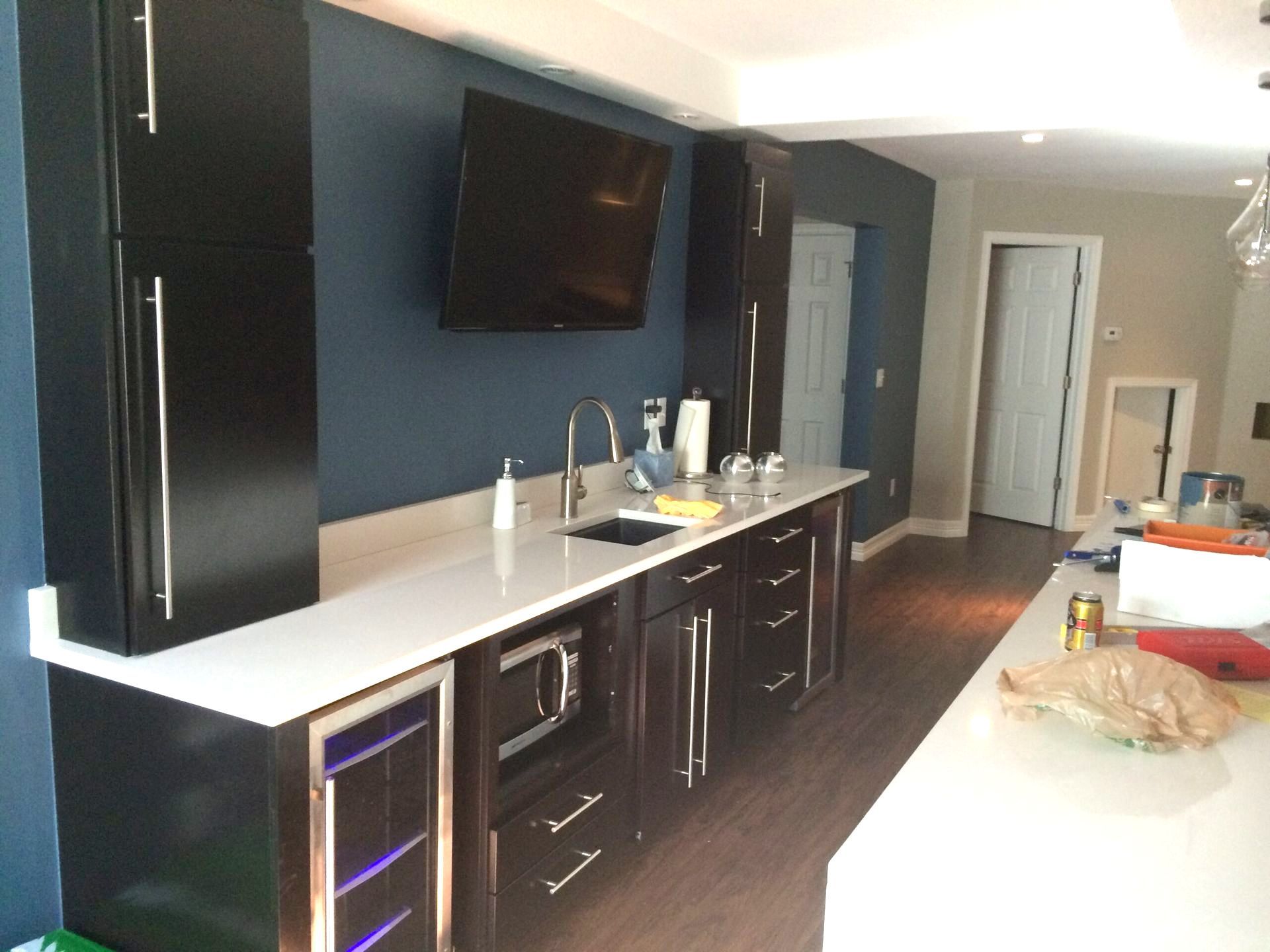 A kitchen with black cabinets and white counter tops