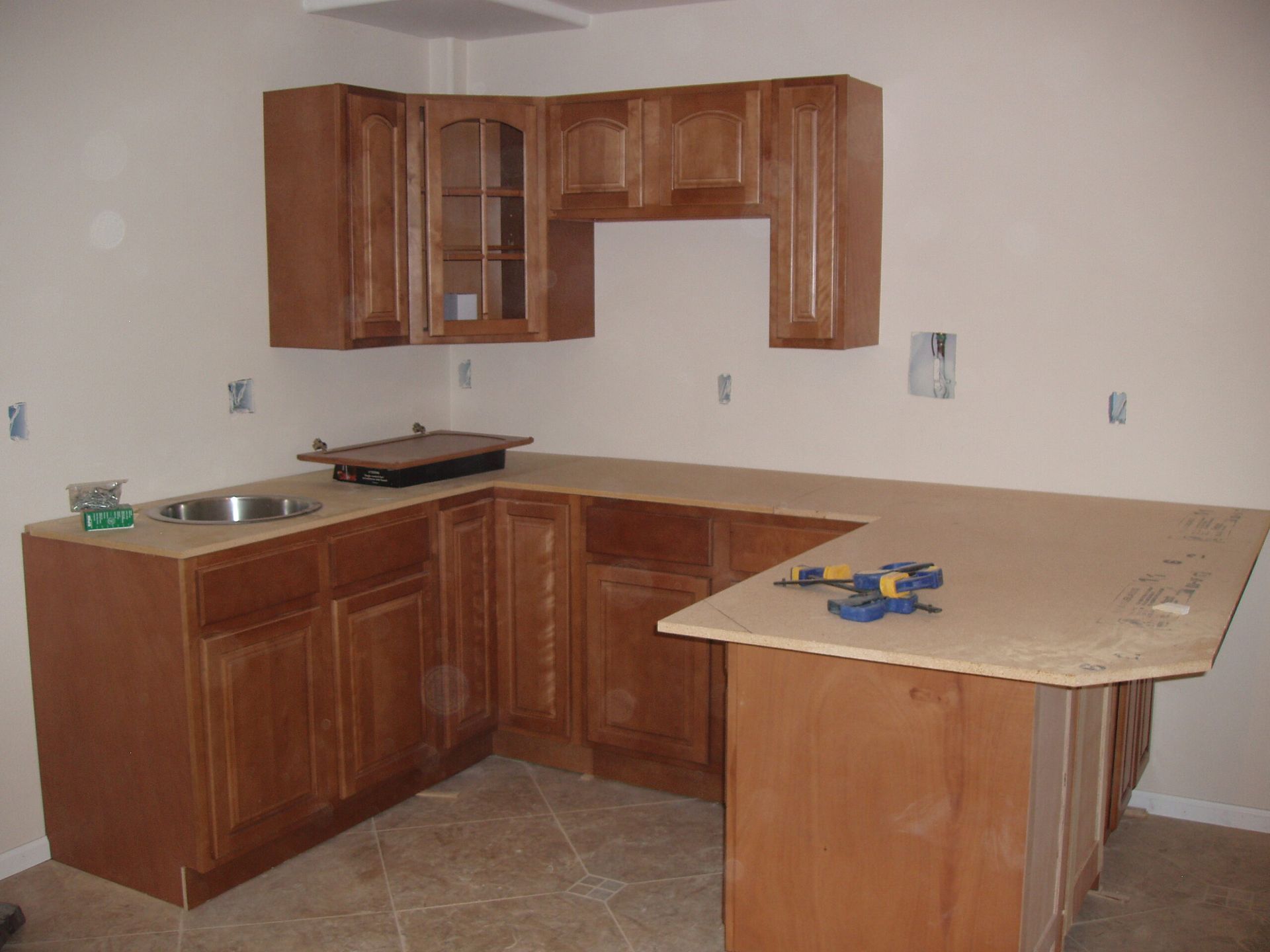 A kitchen with wooden cabinets and a marble counter top