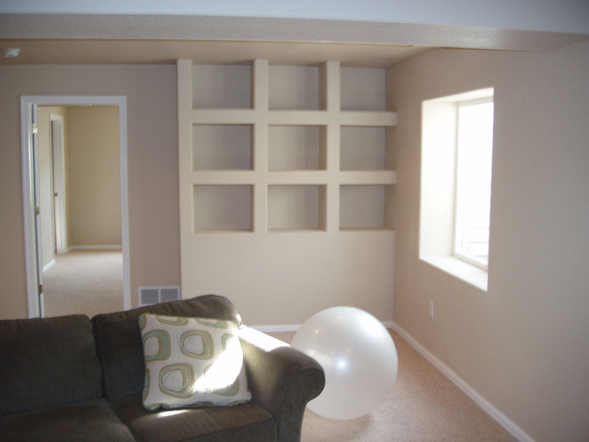 A living room with a couch and a large white ball