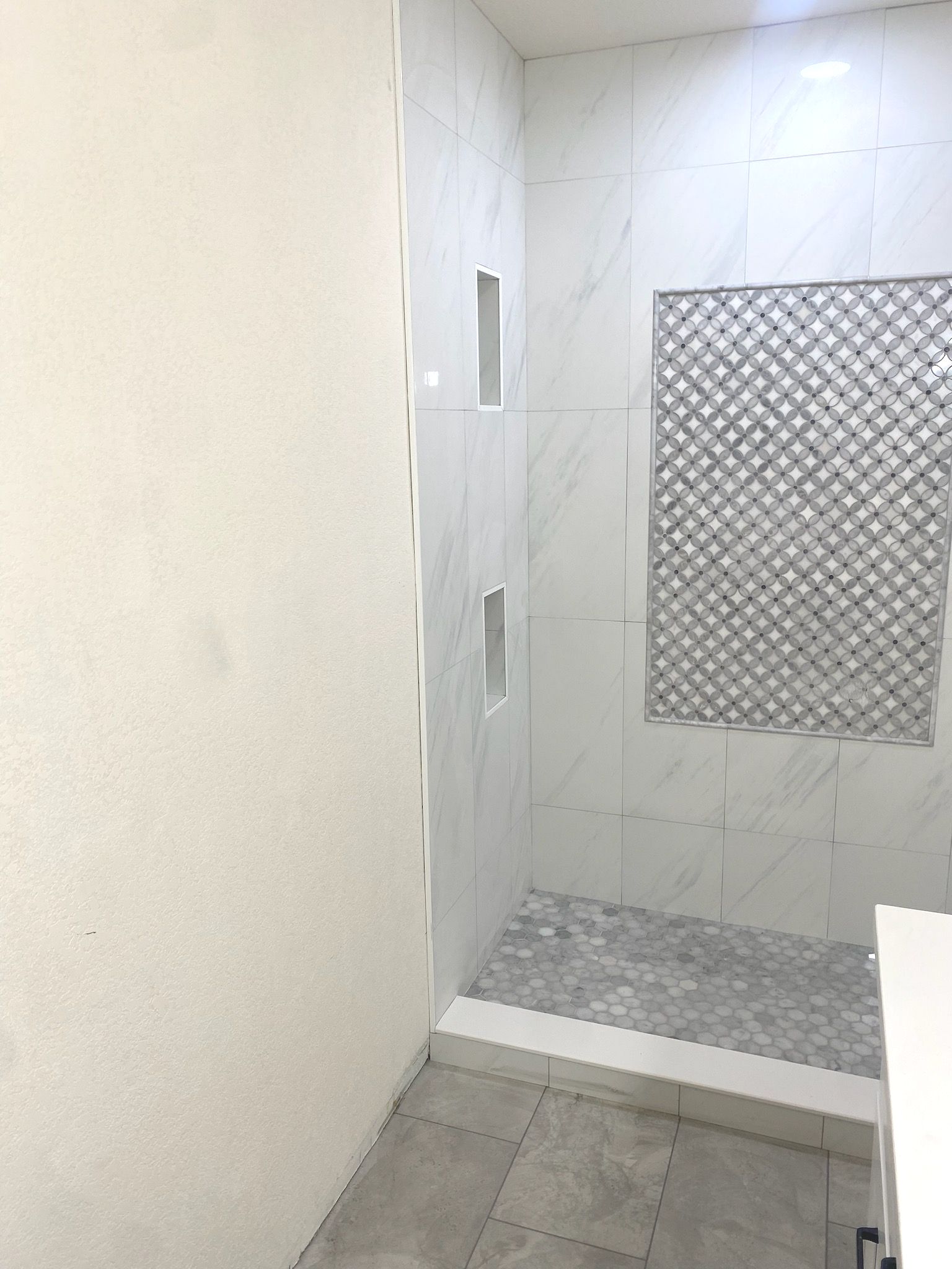 A bathroom with a walk in shower and a sink.