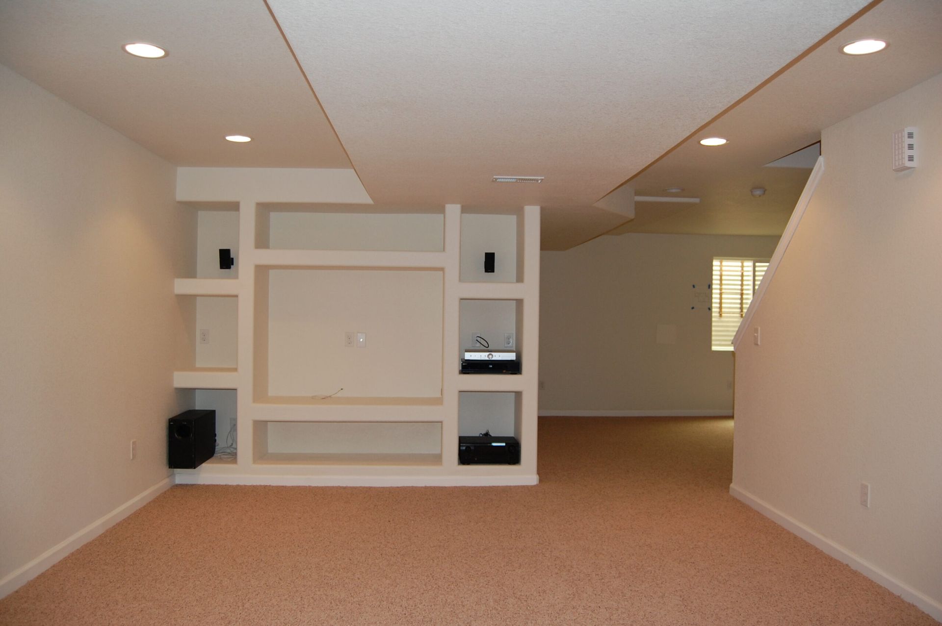 An empty room with a wall mounted entertainment center