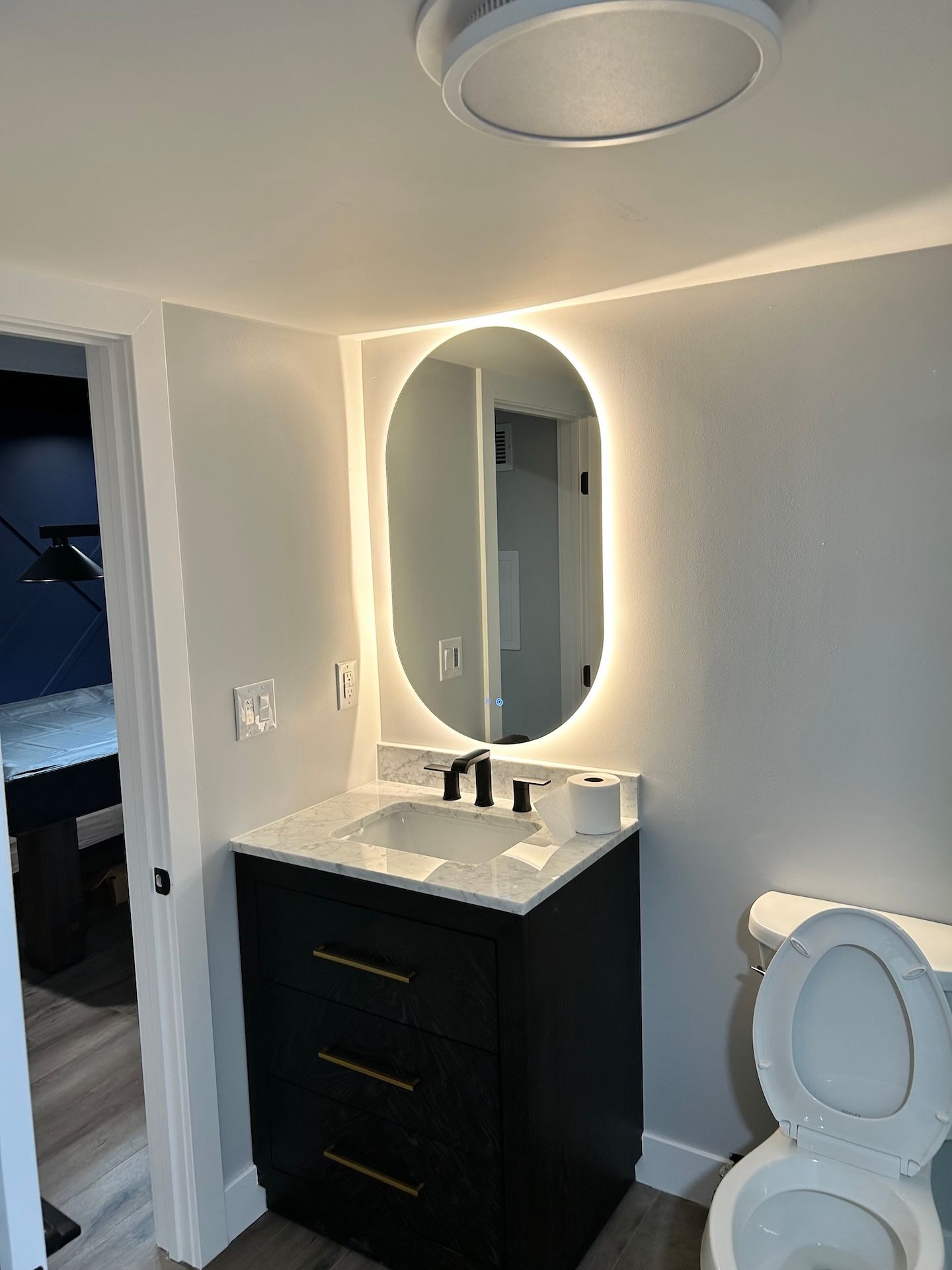 A bathroom with a sink , toilet , shower and mirror.