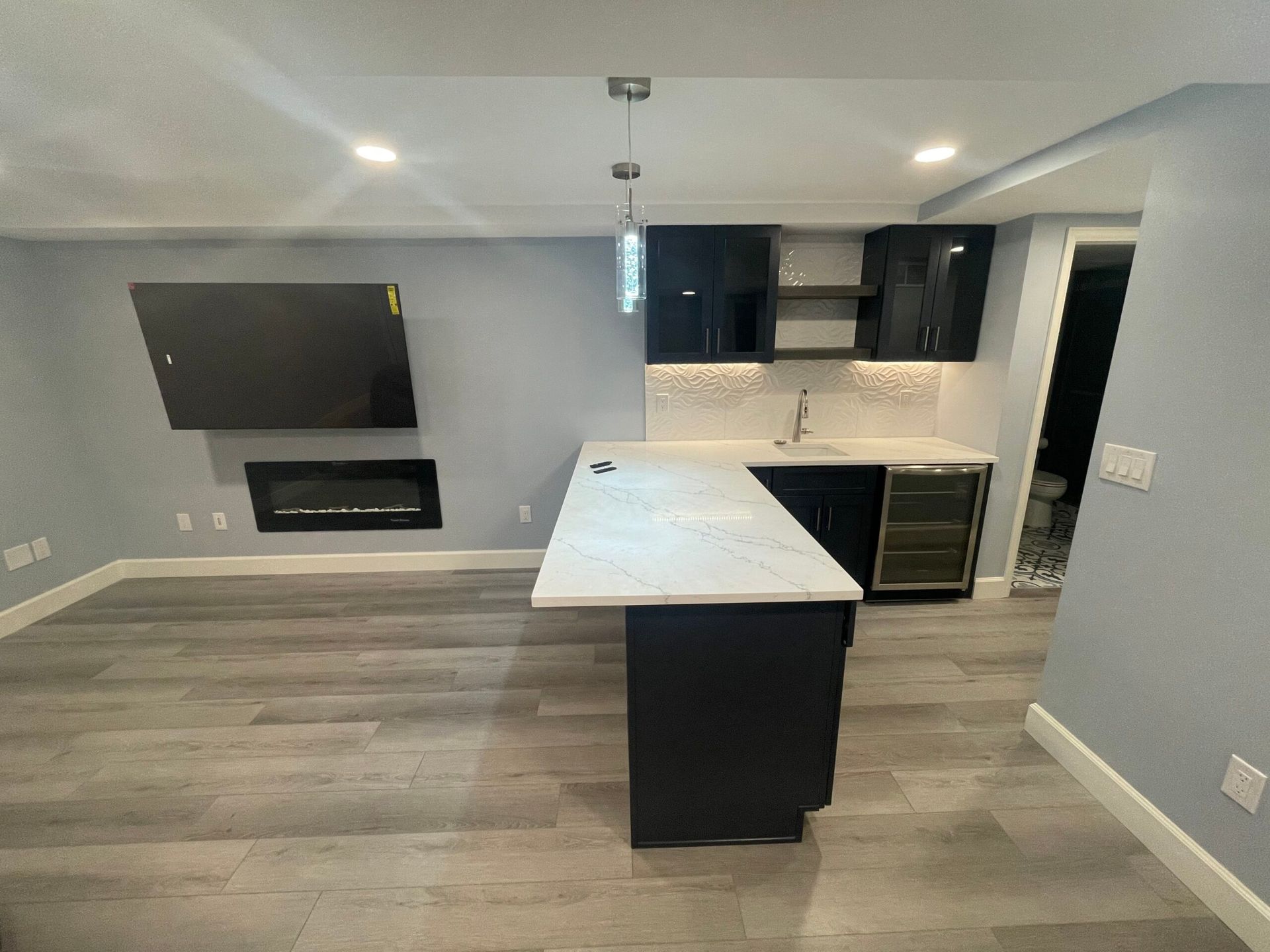 A kitchen with a large island and a flat screen tv on the wall.