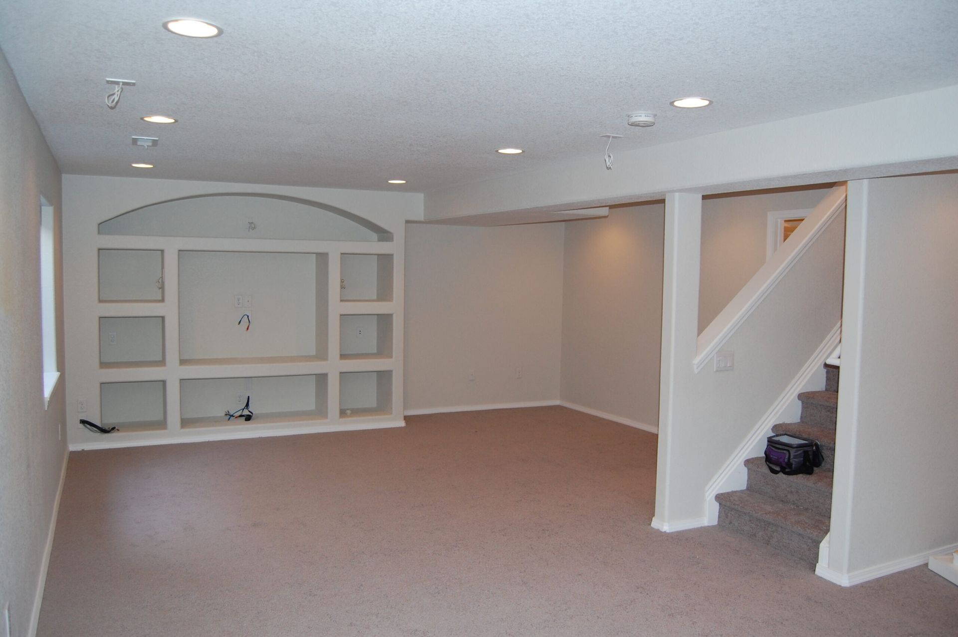 An empty basement with stairs leading up to the second floor