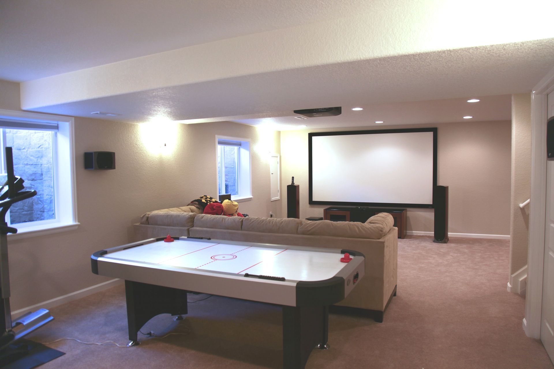 A basement with two exercise bikes and a television