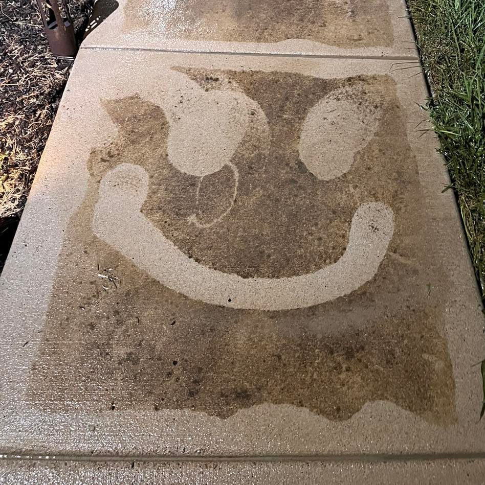 A person is using a high pressure washer to clean a concrete floor.