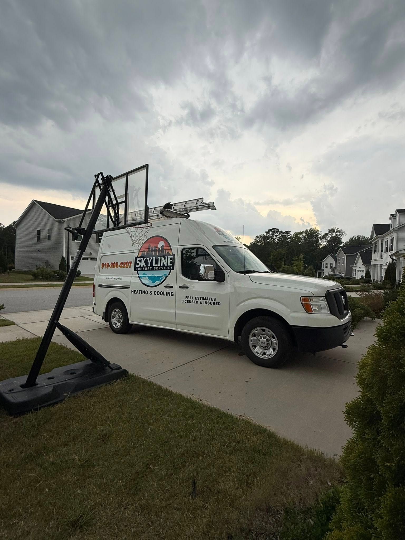 Skyline Comfort Services LLC - White service van parked on a driveway next to a basketball hoop; cloudy sky overhead.