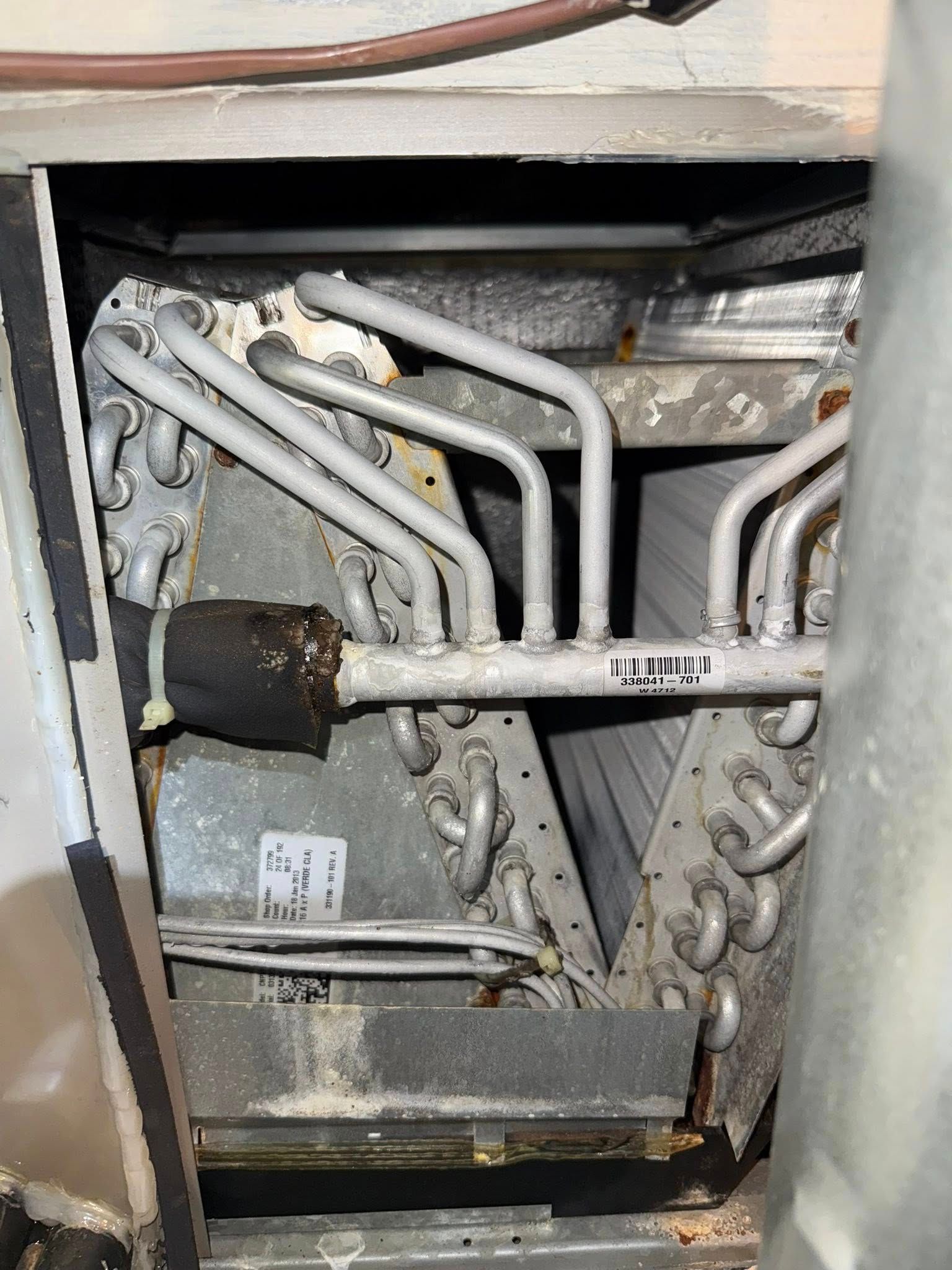 Skyline Comfort Services LLC - A dirty air conditioning evaporator coil unit inside a metal cabinet.