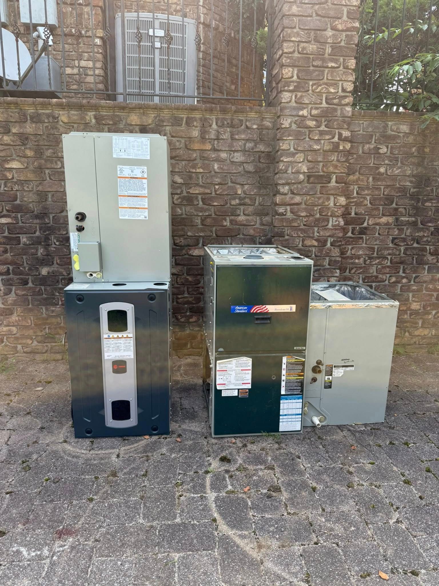 Skyline Comfort Services LLC - HVAC units arranged outside brick building. Vertical, metal units: one stacked, one green.