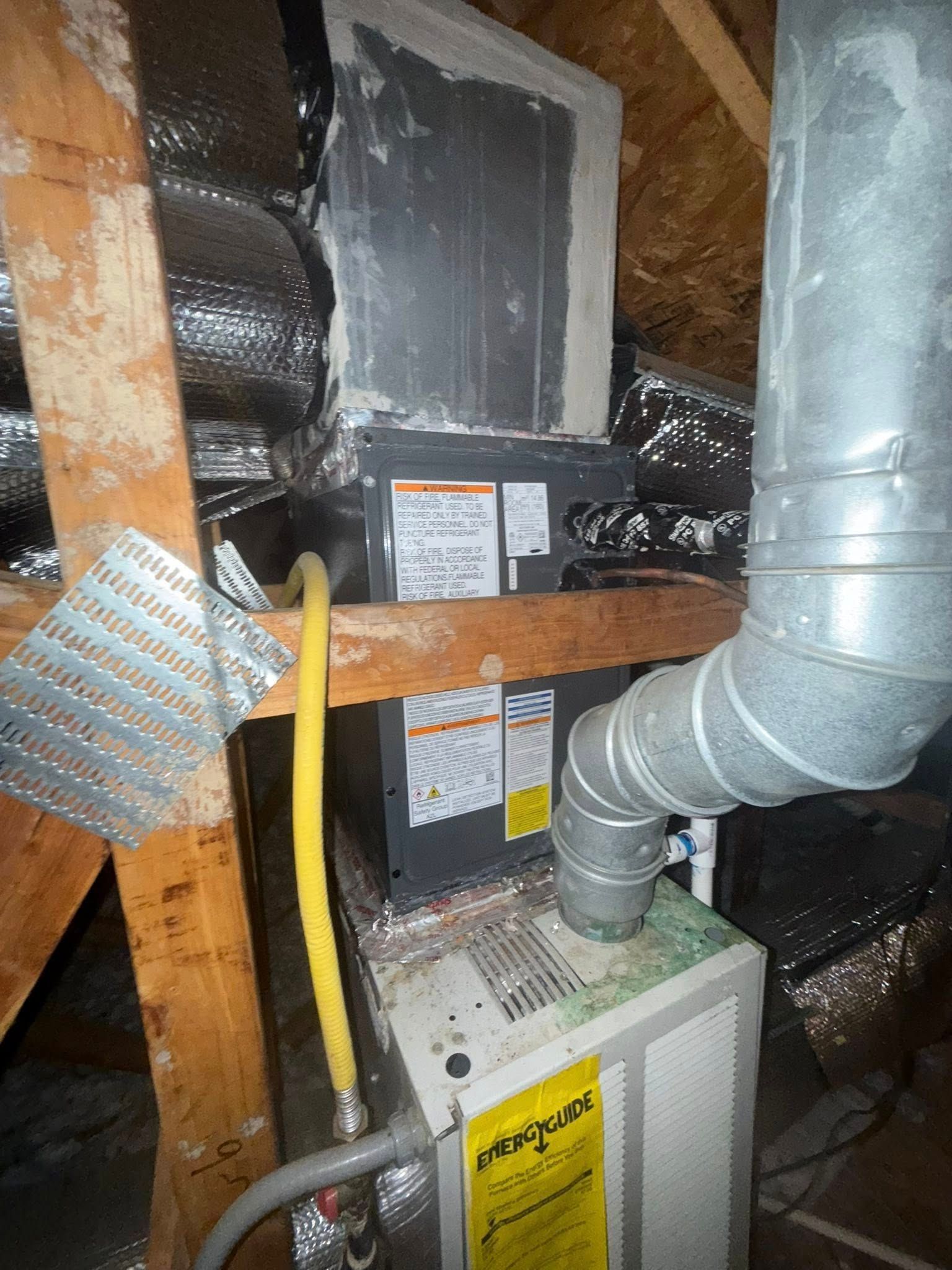 Skyline Comfort Services LLC - HVAC system in attic: furnace below an air handler, yellow gas line, silver ductwork.