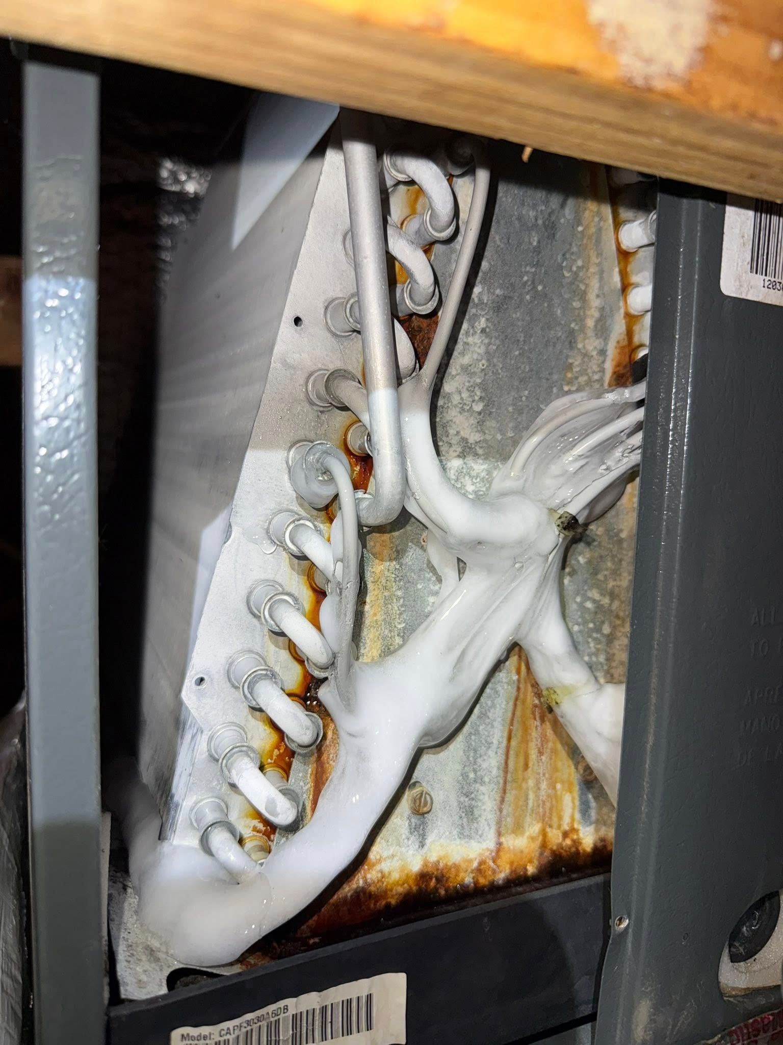 Skyline Comfort Services LLC - Indoor HVAC unit with frozen coils, covered in ice and rust.